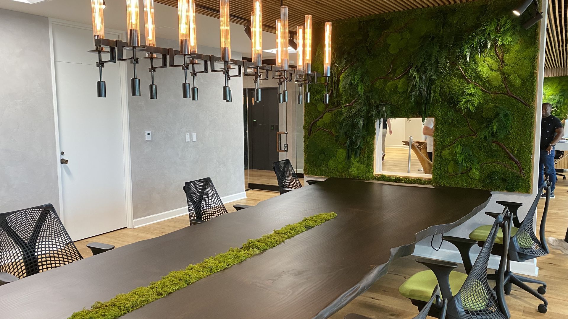 Conference table made of a fallen tree and a wall covered with preserved moss 