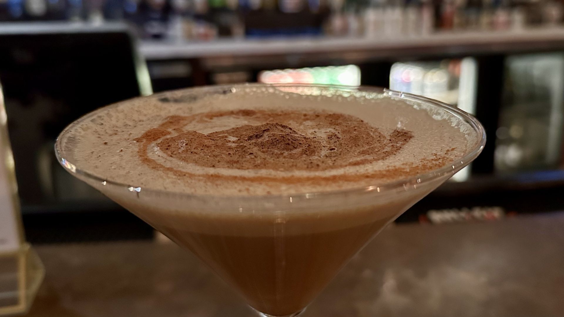 A close-up of an espresso martini with a swirly top