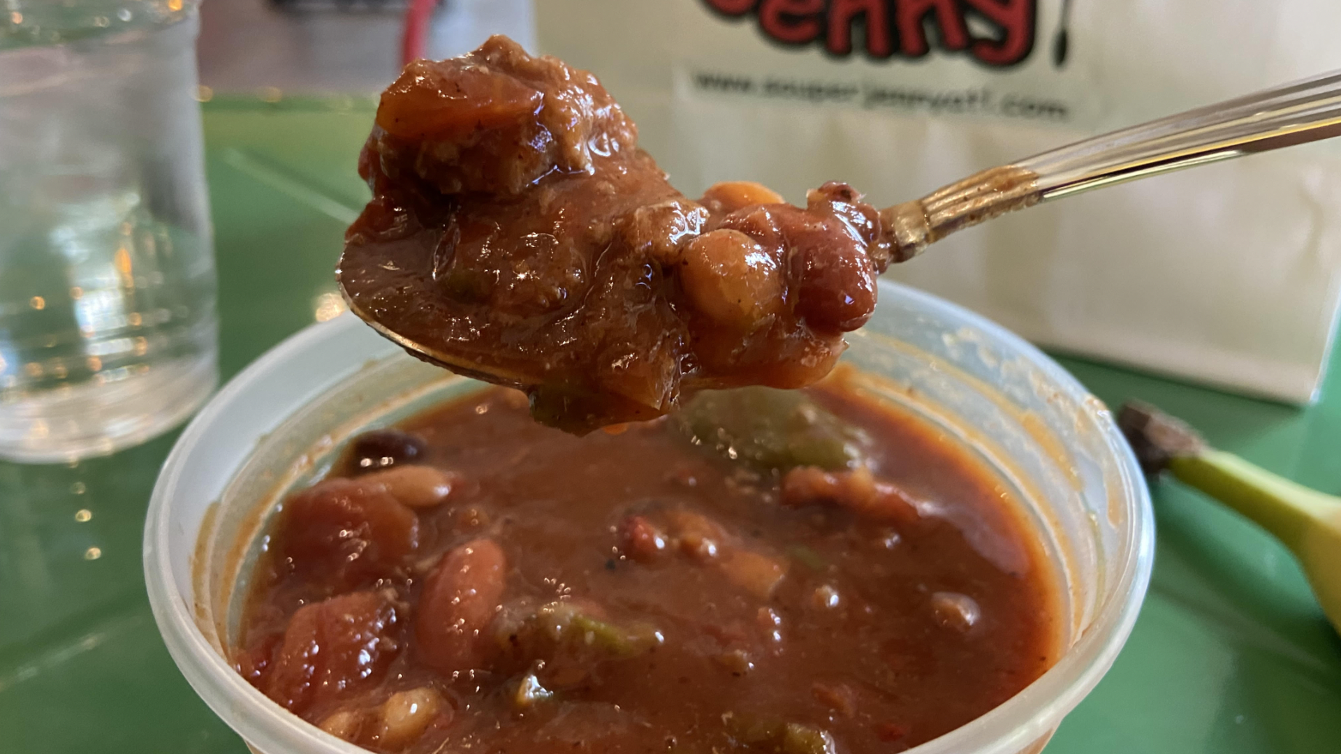 A close-up photo of turkey chili on a green table with a Souper Jenny bag in the background