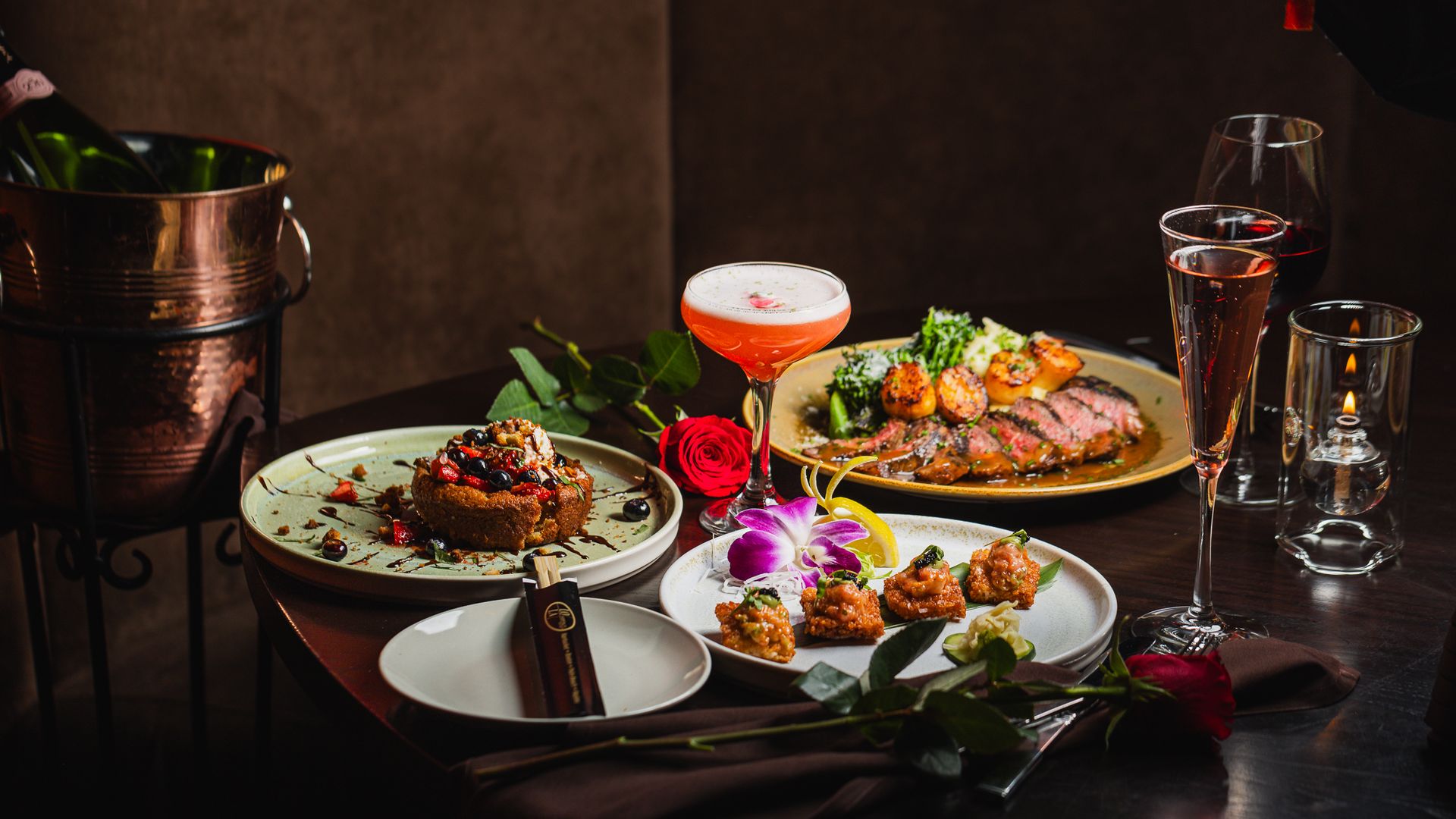 A small table showing LoLa 42's Valentine's Day menu, which includes toro crispy rice, grilled NY strip and seared scallop, a banana butter cake and a tequila cocktail called the "heartburn."