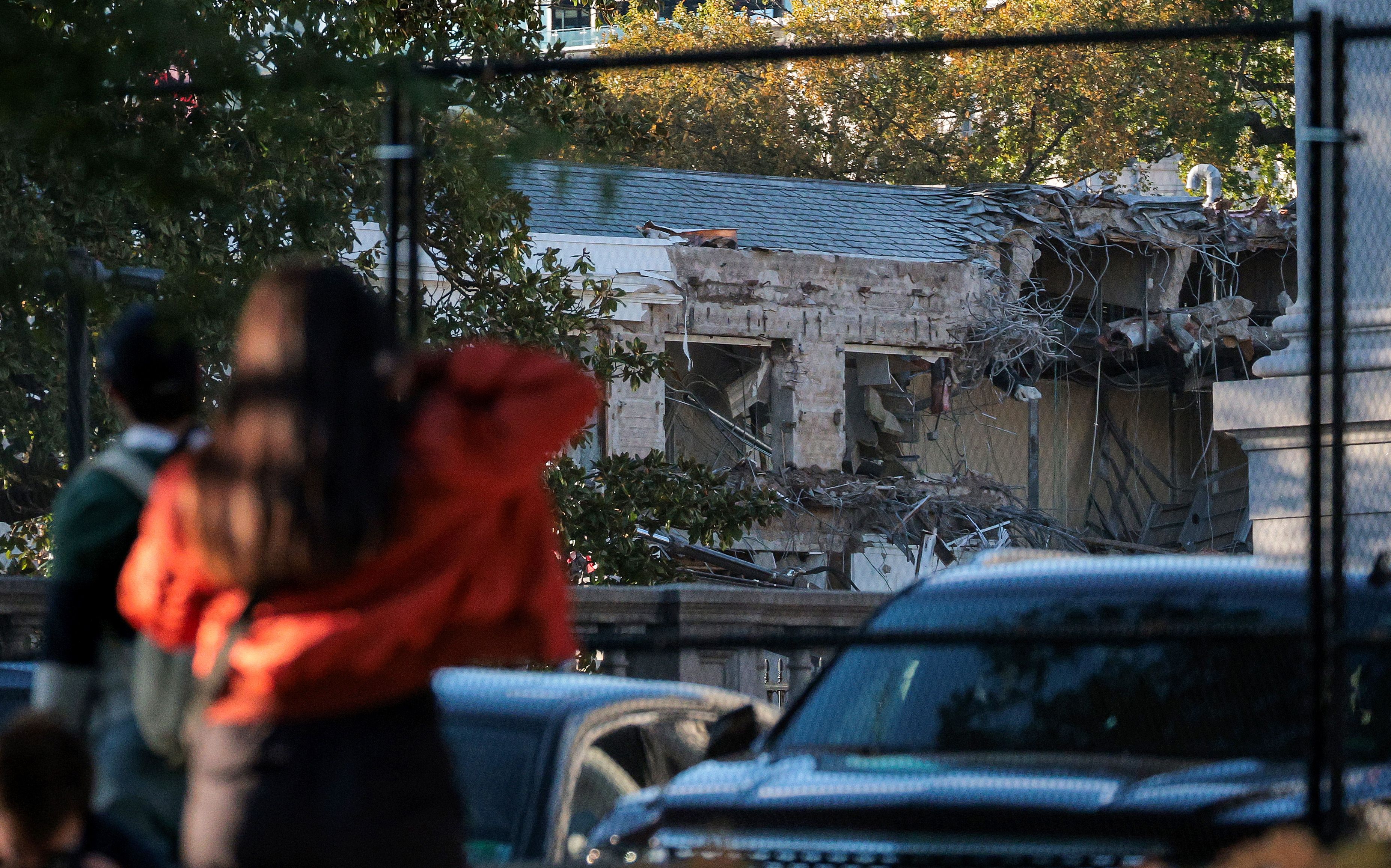 People watch as work crews demolish the facade of the East Wing of the White House on Oct. 20 2025. 