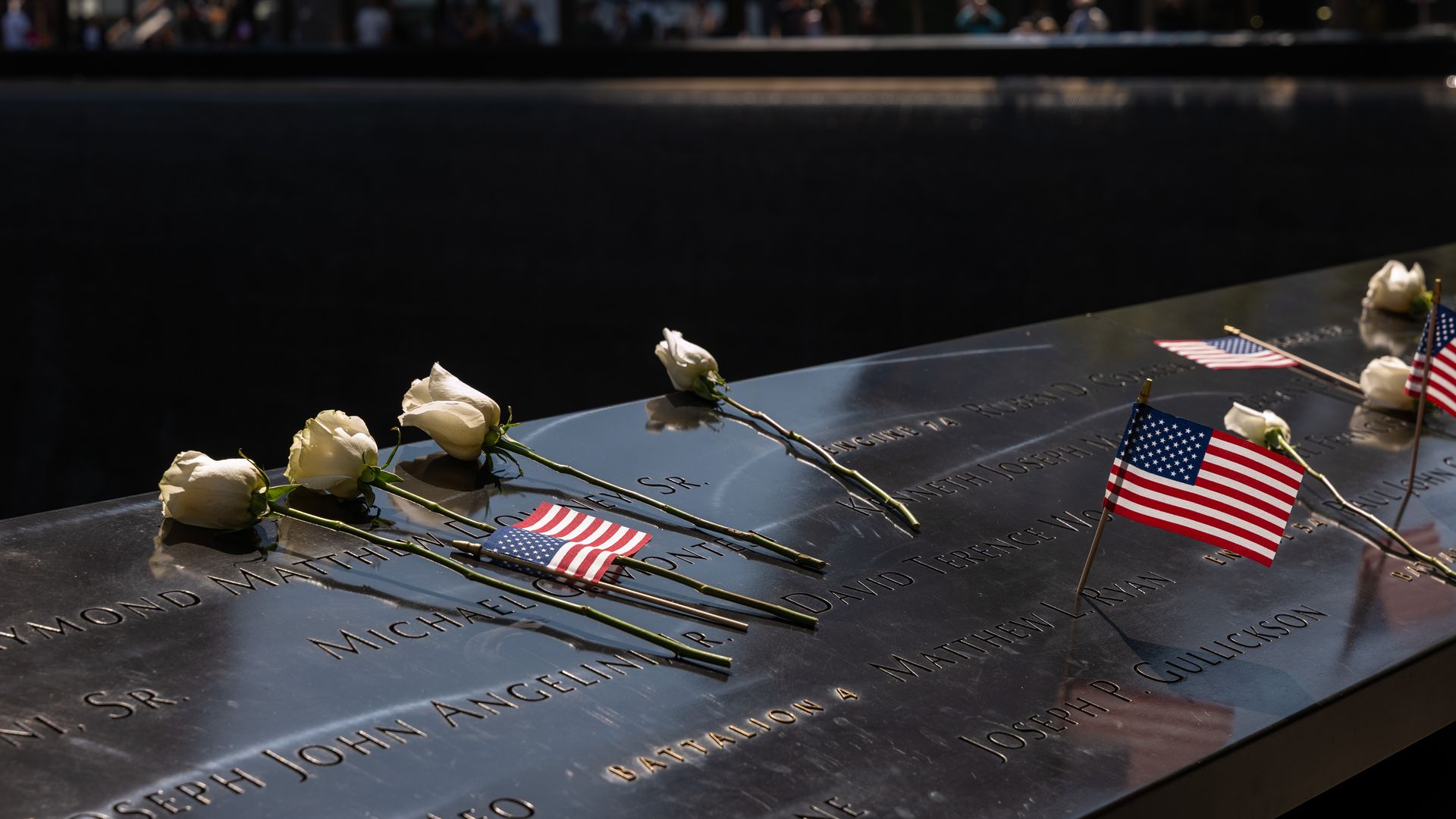 White roses and american flags on the sept. 11 memorial in new york city