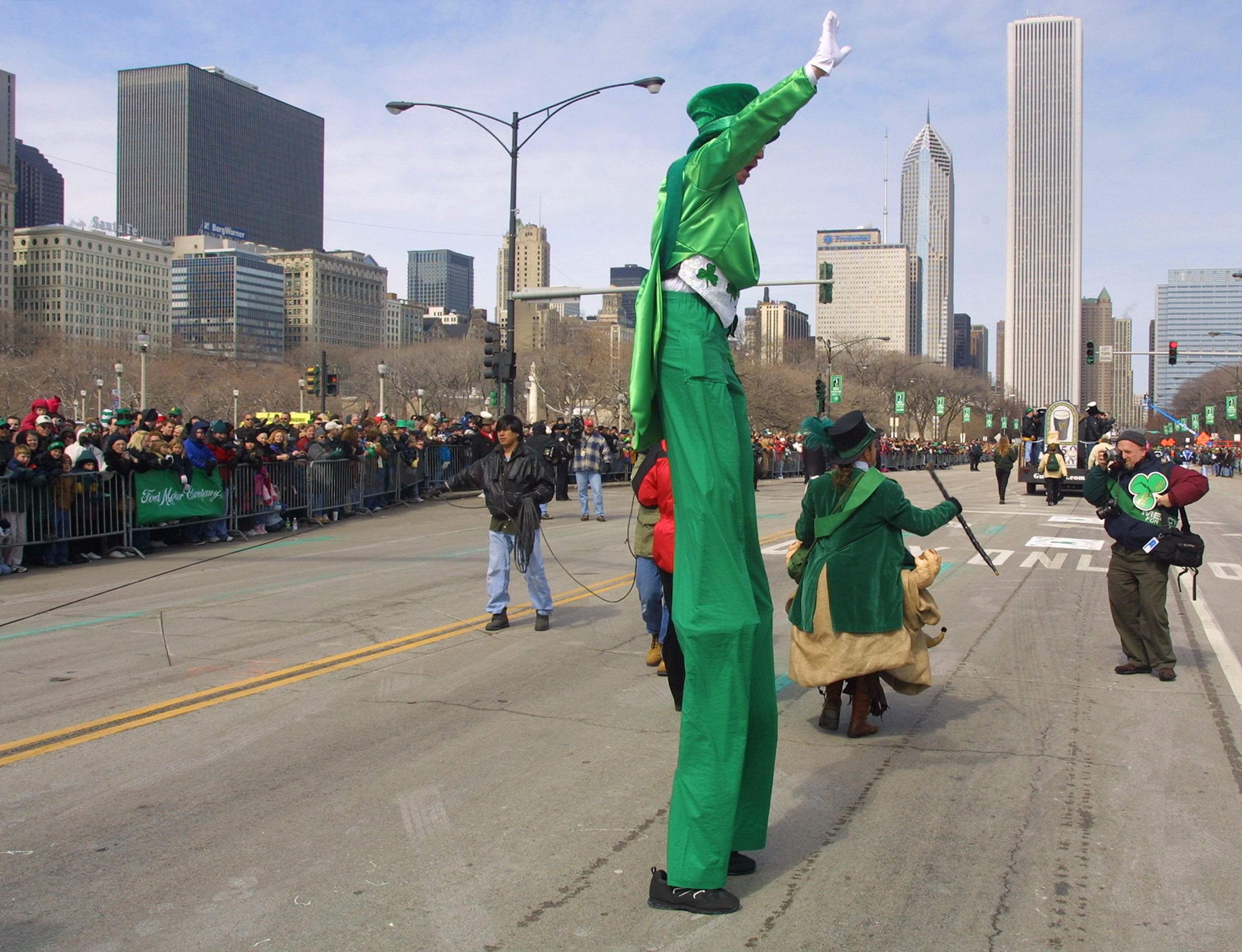 Photo of a man on stilts walking in a parade.