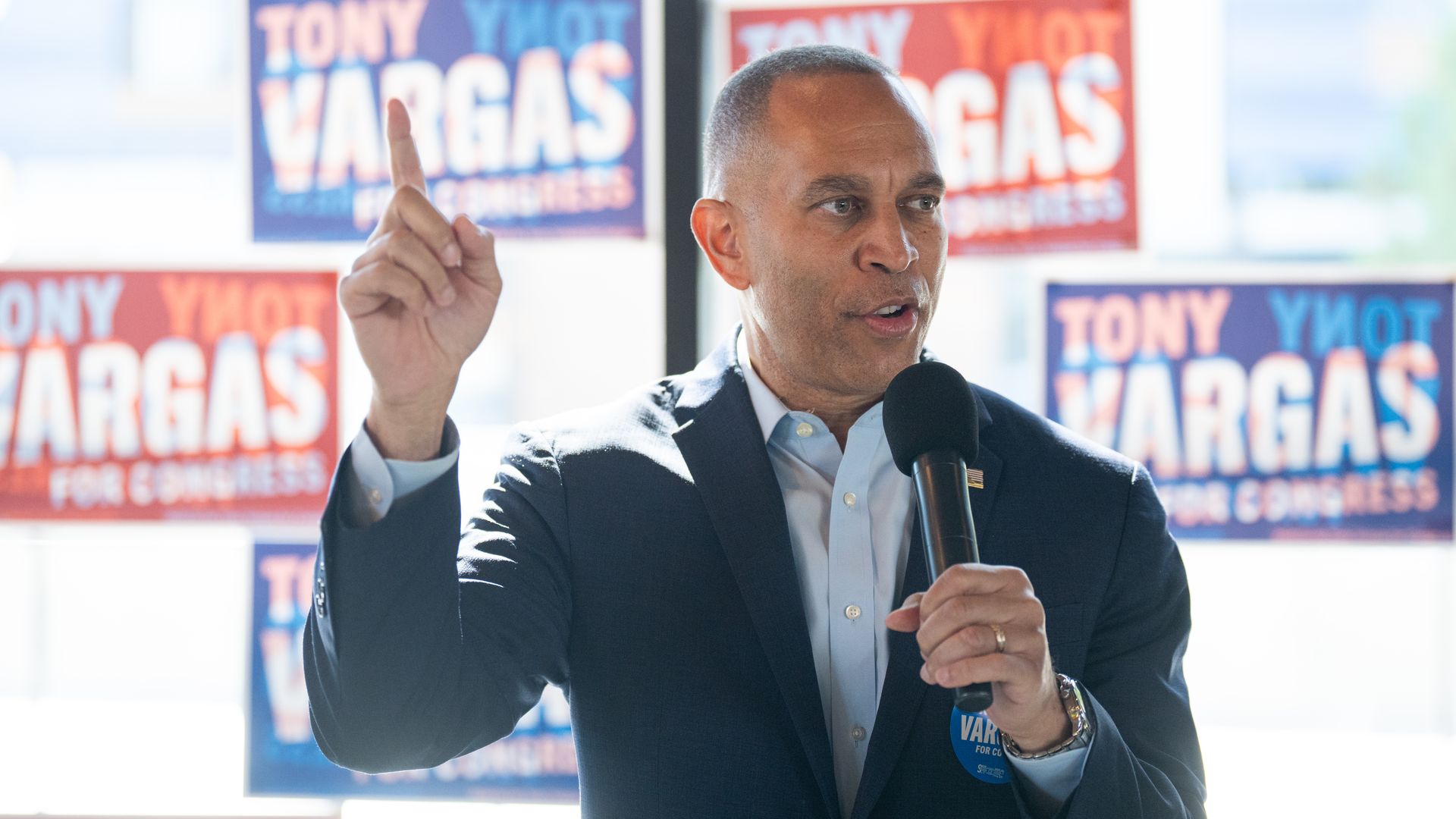 House Minority Leader Hakeem Jeffries, wearing a blue suit and raising a finger