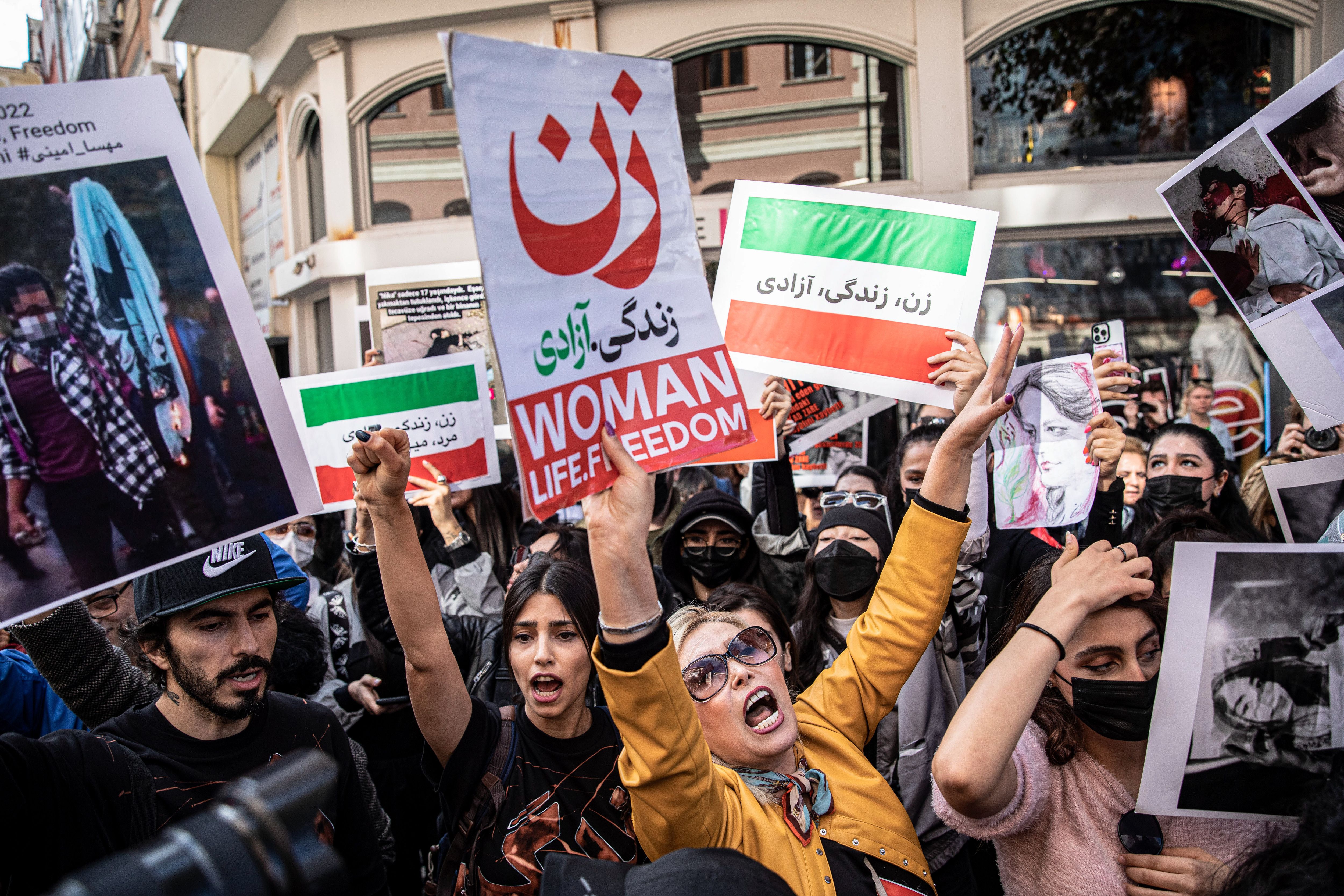Protesters hold placards and chant slogans outside the Iranian Consulate in Istanbul Mahsa Amini.