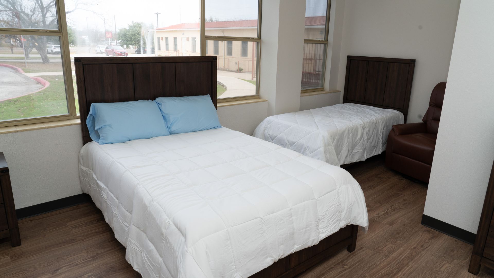 A bedroom at the new YWCA women's center shows a bed in a light-filled room with a child's bed next to it.