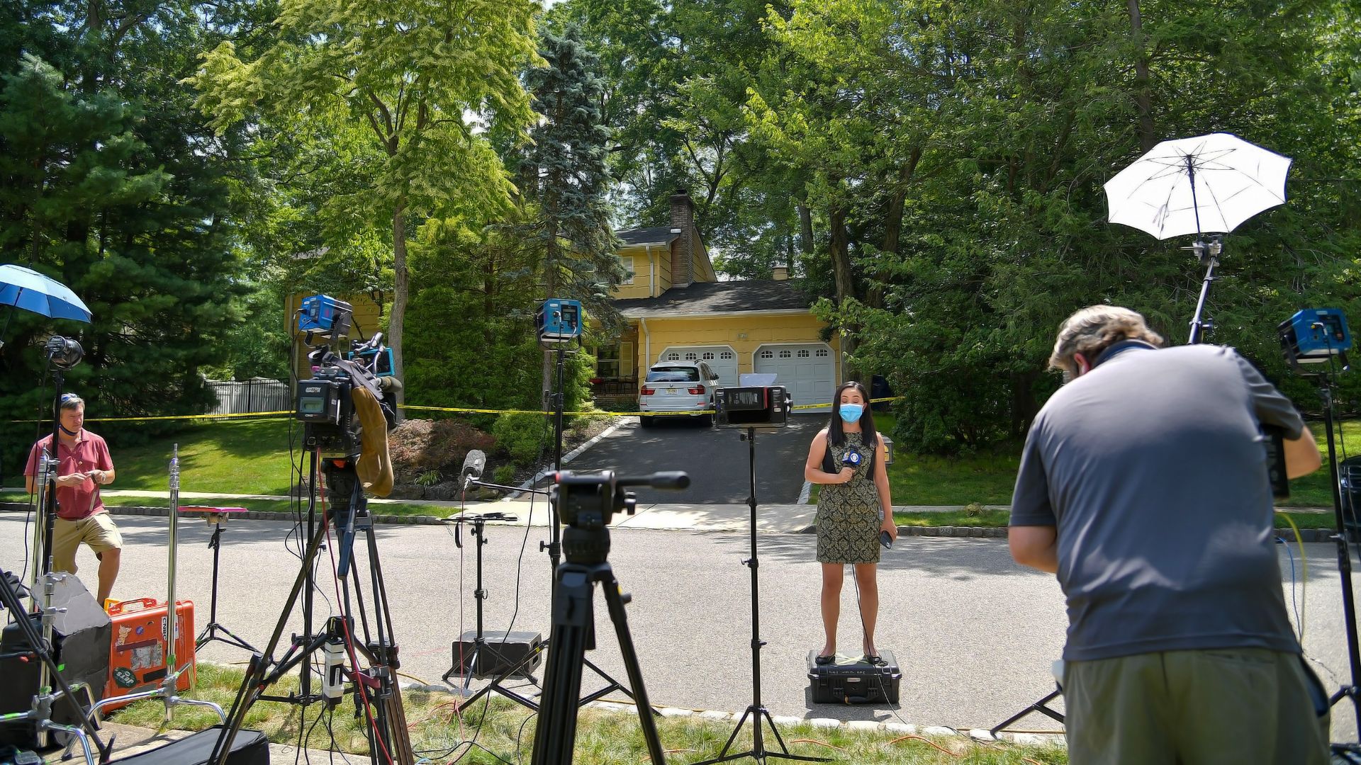 A reporter is seen outside the New Jersey home of a federal judge after her husband and son were shot by an attacker.