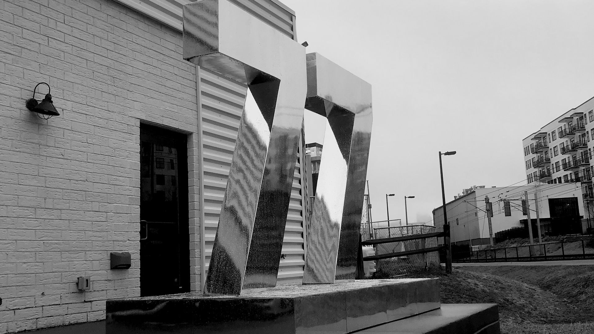 black and white photo of a human-sized statue that says 77