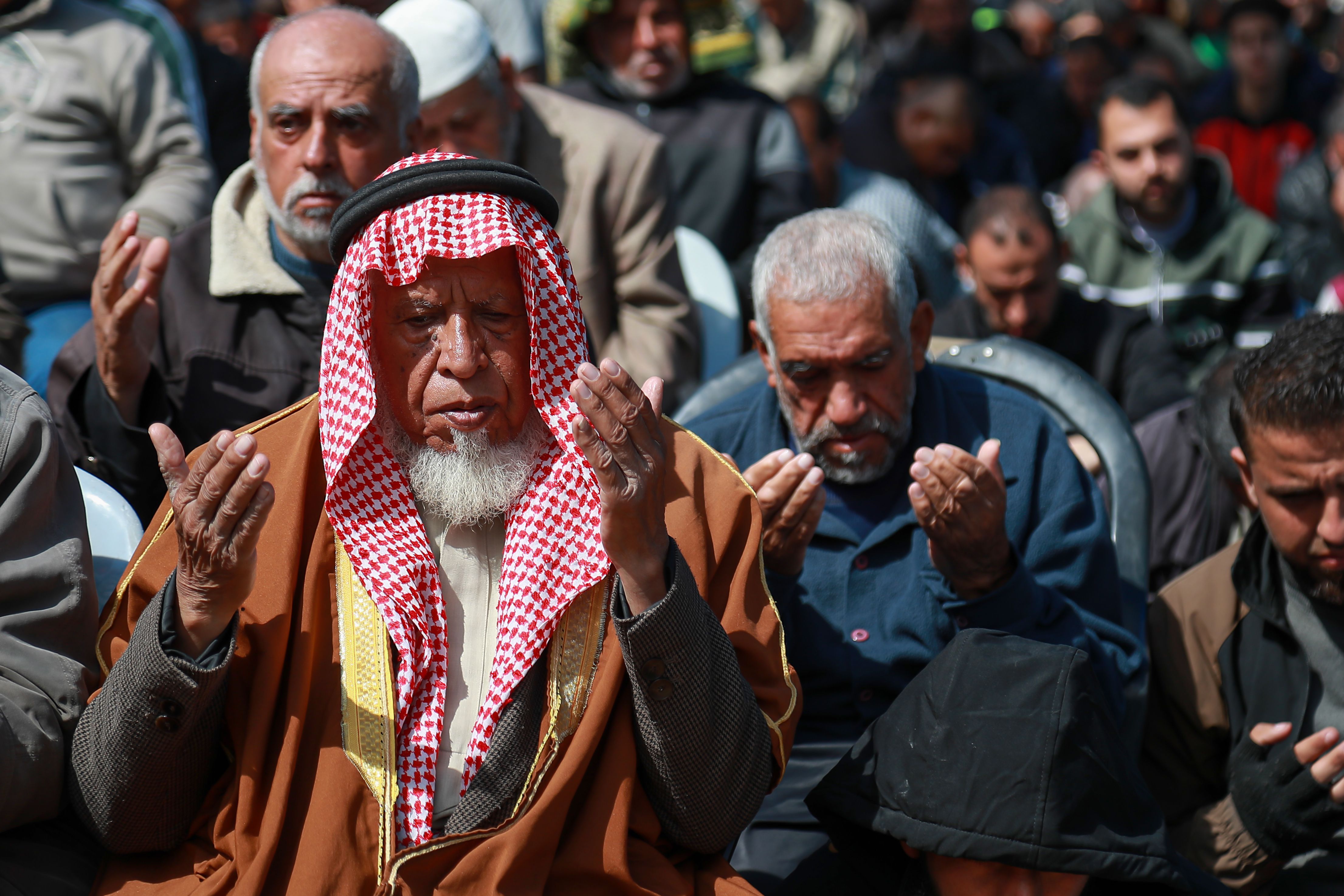 A close up shot of men performing Islamic prayer. 