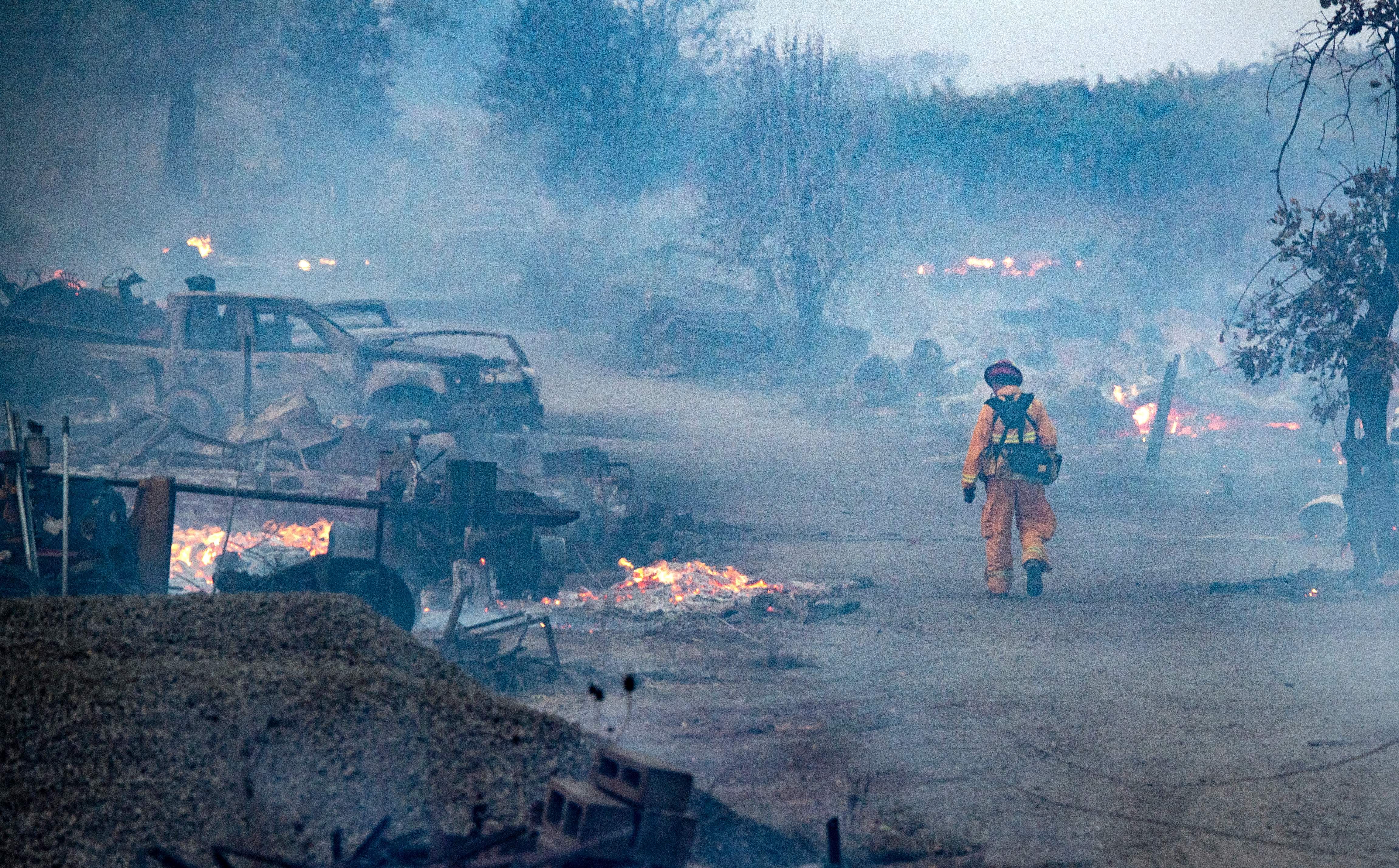 A firefighter walks through a burned property after the Kincade fire tore through Healdsburg