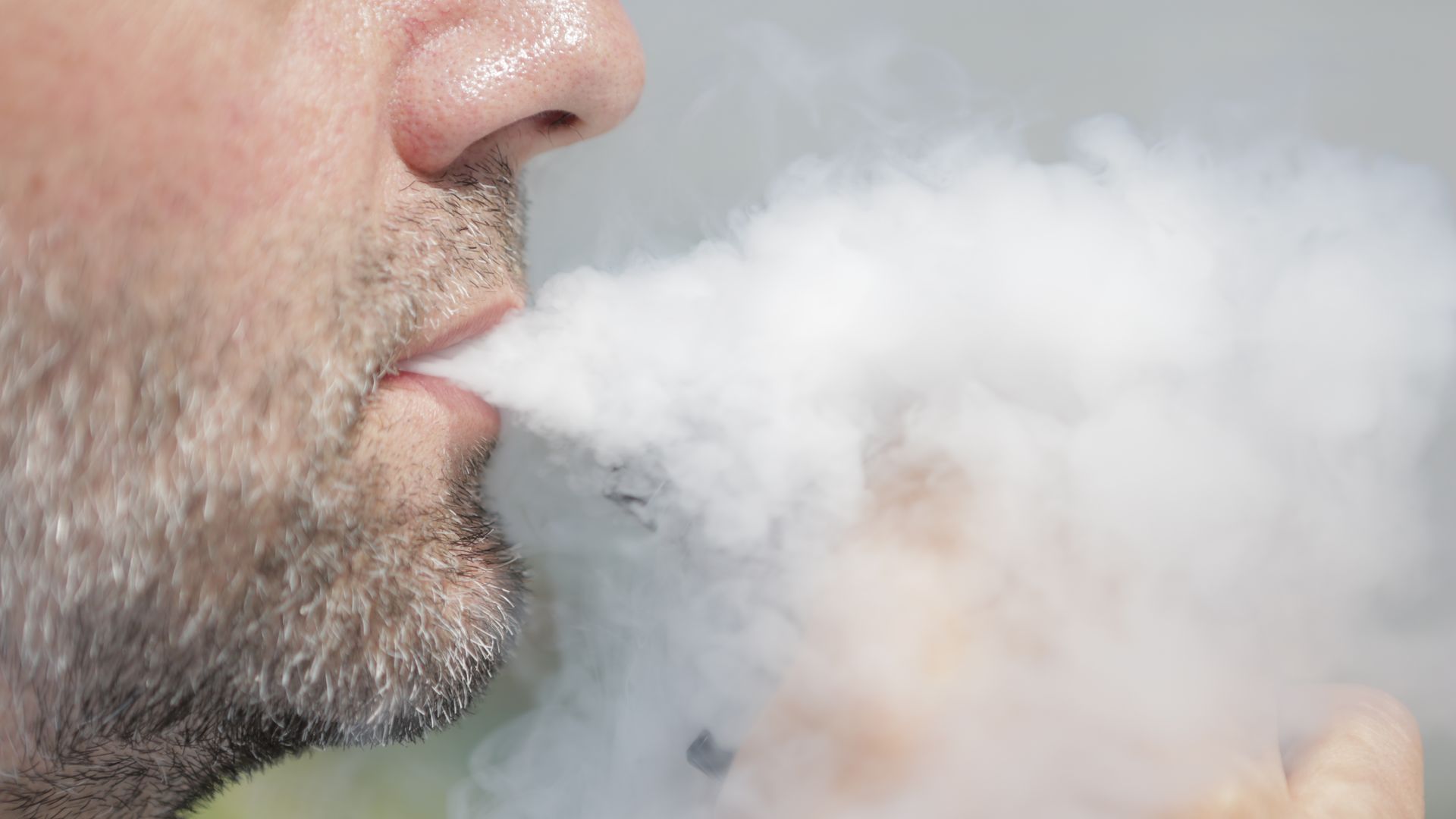 A person smokes an e-cigarette.