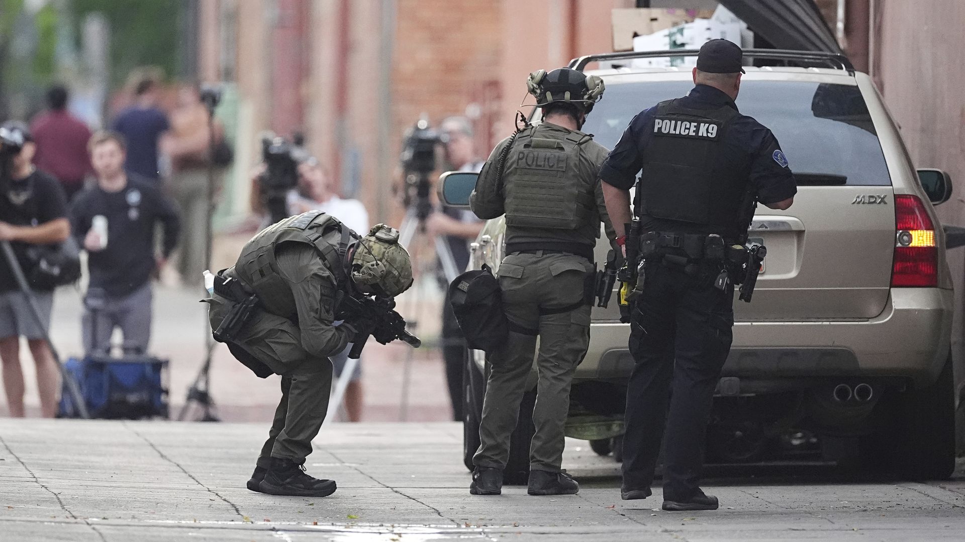 police officers are standing on the sidewalk near a crowd of people