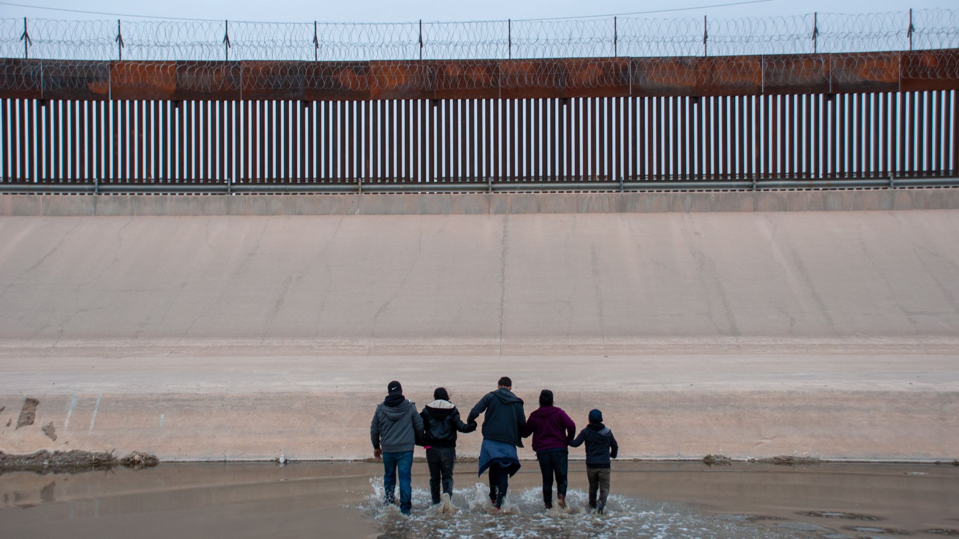 A migrant family is seeking crossing the Rio Brava River from Ciudad Juarez, Mexico.