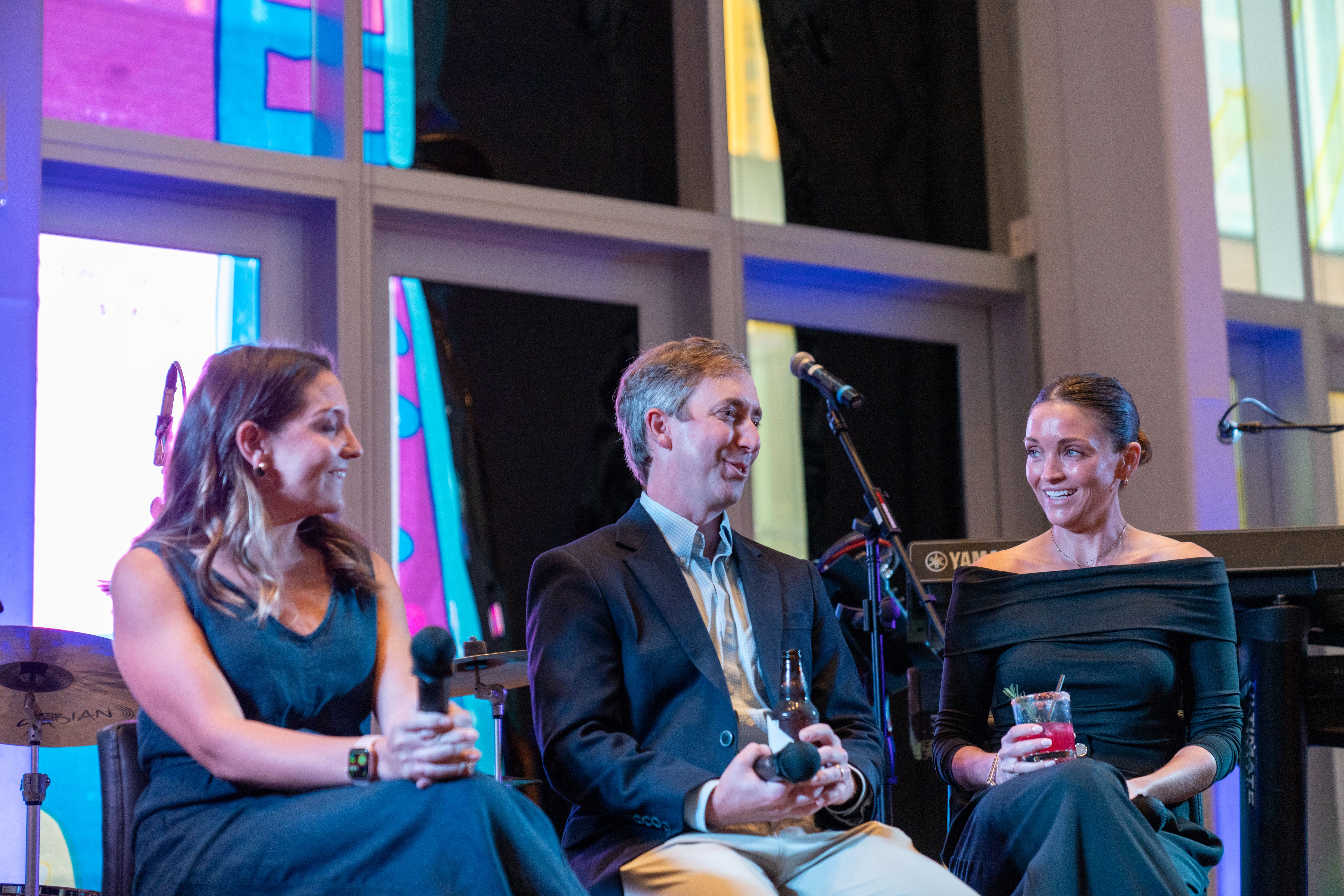 Three people seated on a stage in conversation.