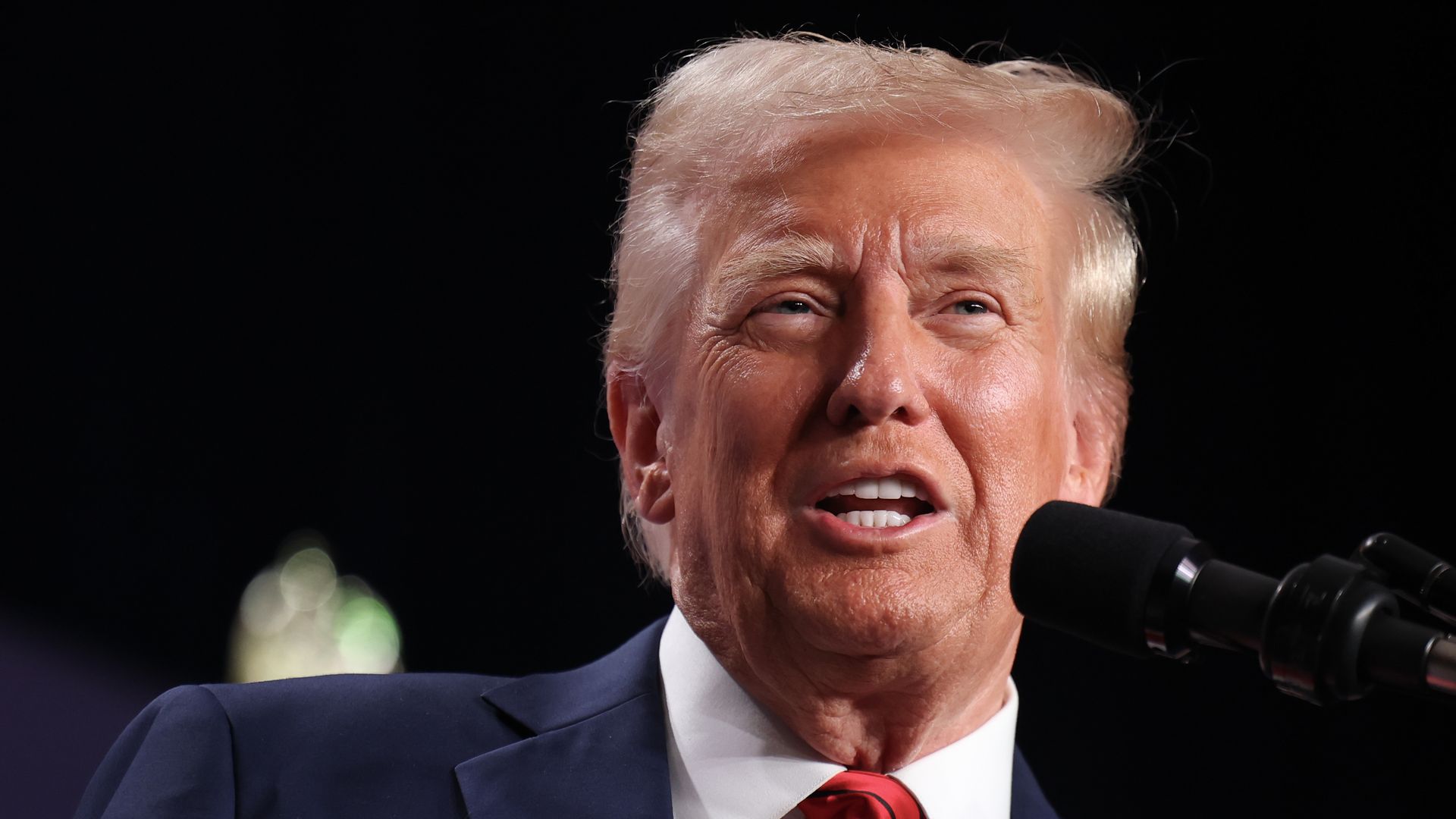 A photo of President Trump speaking into a microphone.