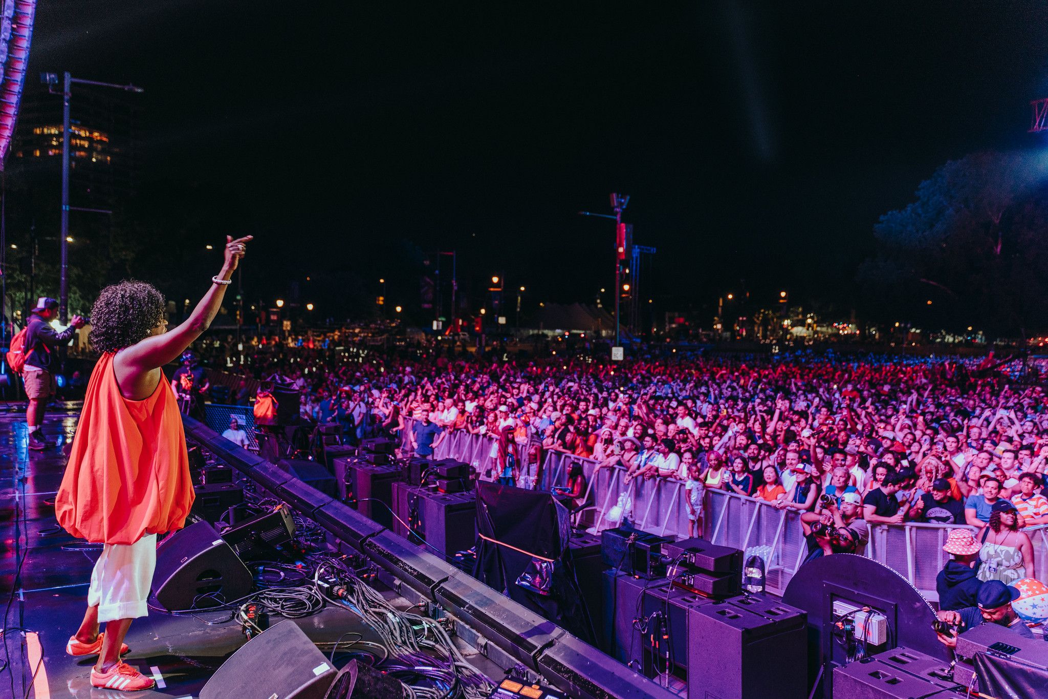 Mayor Cherelle Parker raises her arm toward a large, cheering crowd from the stage of the One Philly Unity Concert for America.