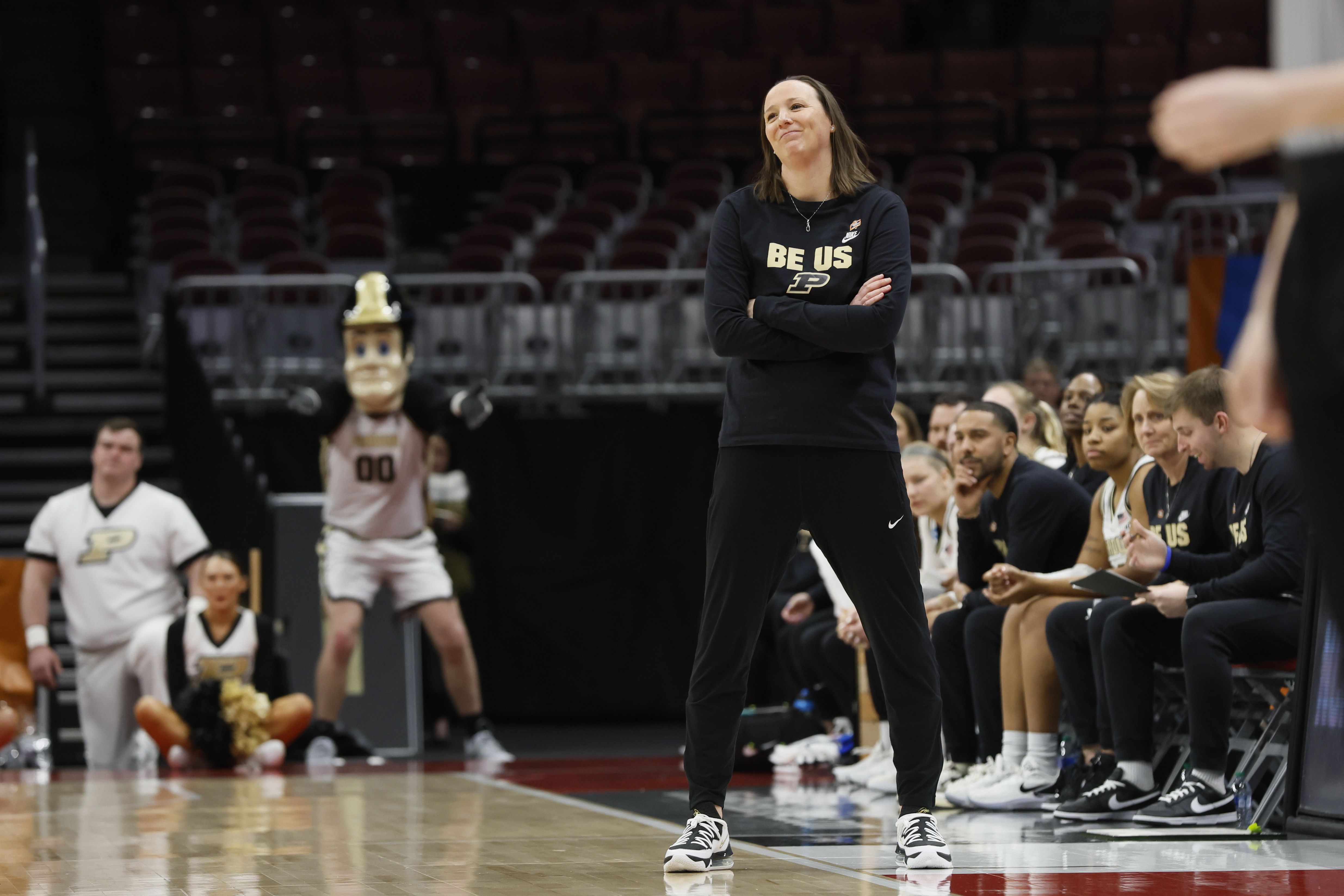 Photo of a coach watching her players play a game of basketball