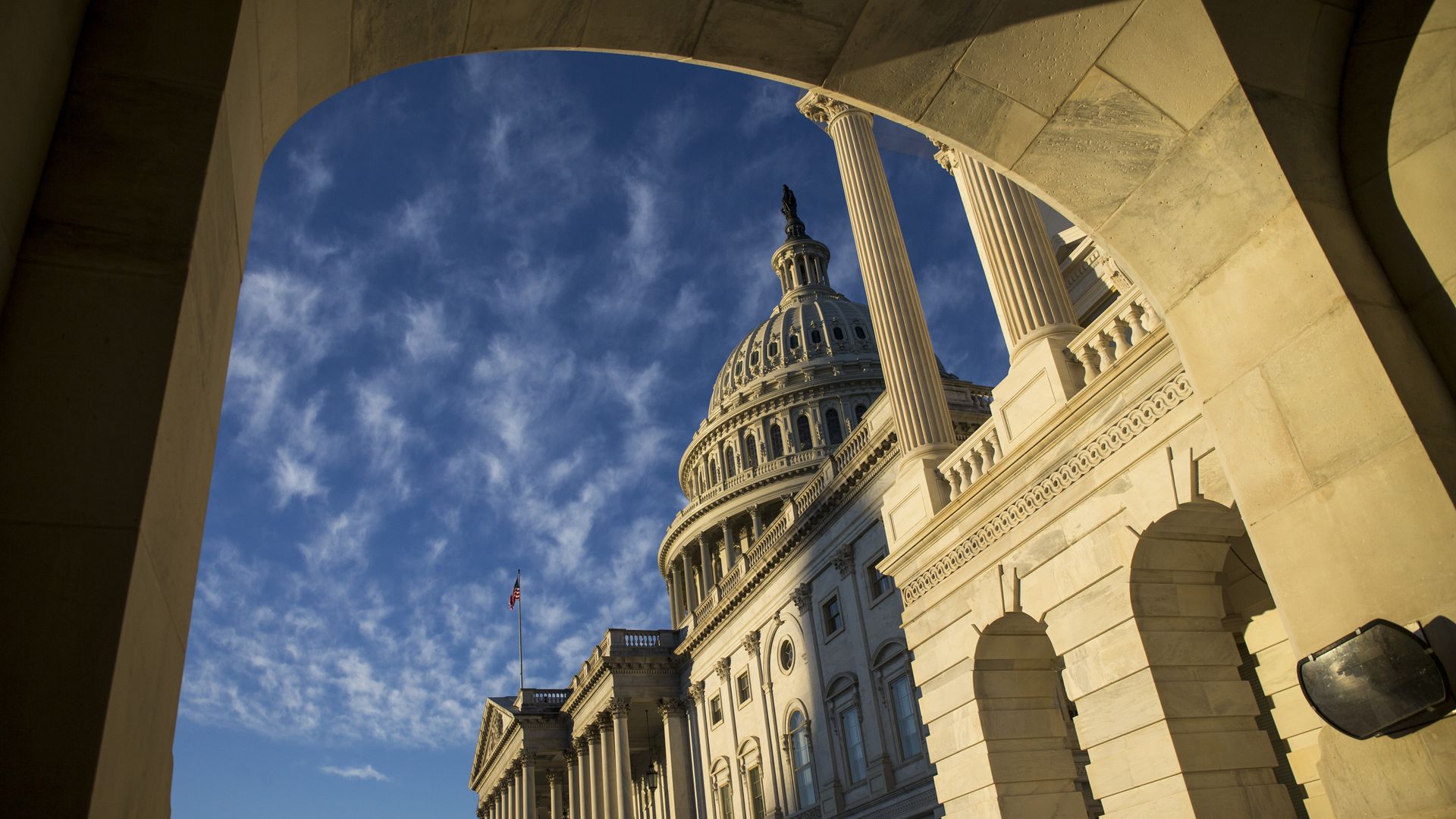 The exterior of the Capitol dome pictured through an archway