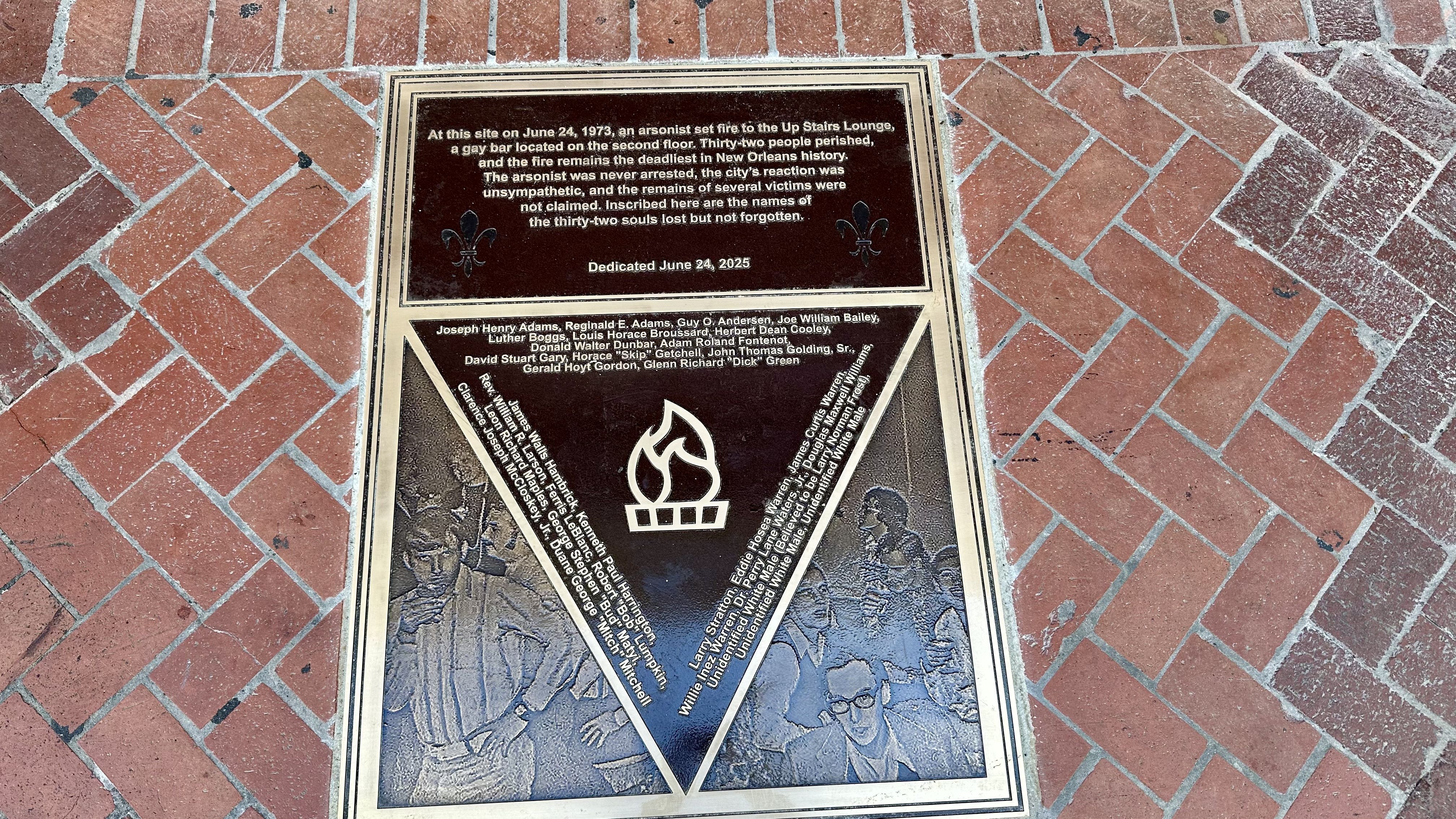 Image shows the new plaque for the Up Stairs Lounge fire embedded in the sidewalk.