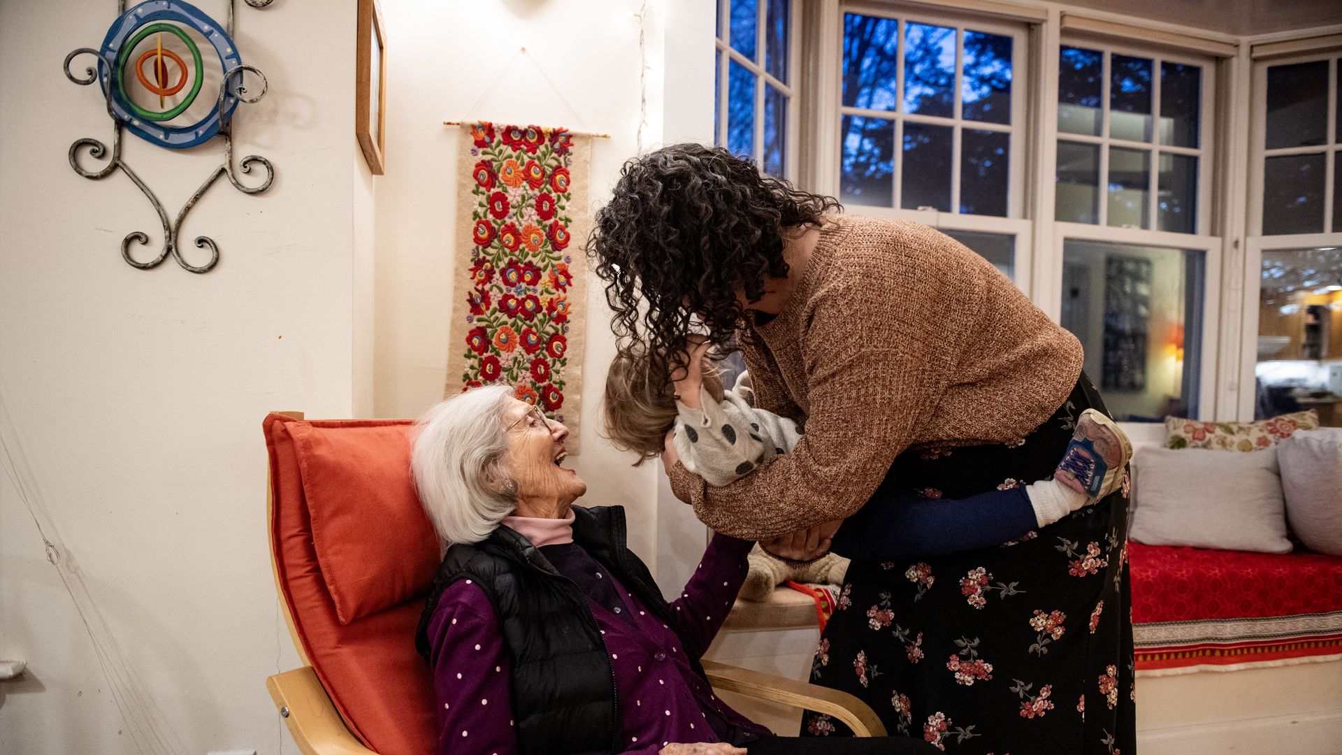 Holocaust survivor Magdalen Bader, 94, is greeted by one of her grandchildren holding a great-grandchild while at her daughter's house for a Hanukkah celebration in Newton, Massachusetts. Born in 1930 in Czechoslovakia, Bader was deported to Auschwitz at the age of 14.