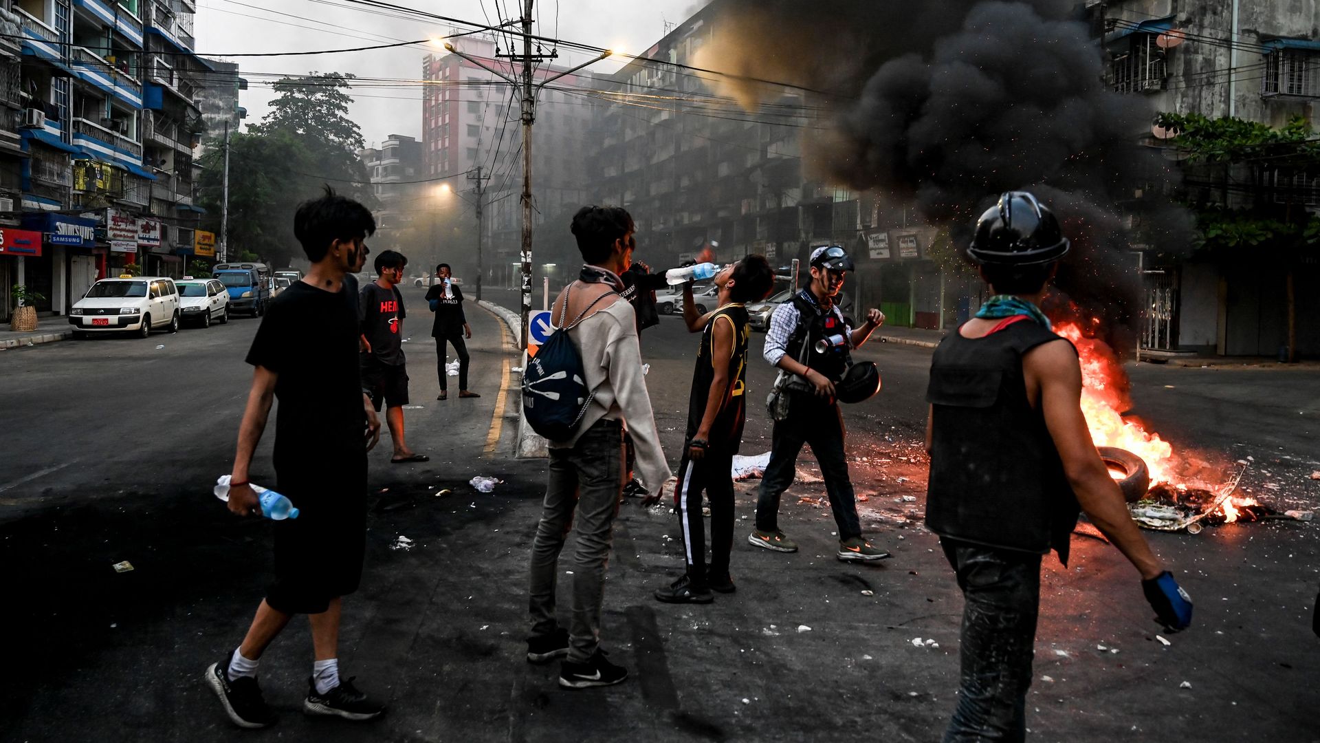 Protesters standing by burning material during a protest against the military coup in Yangon on March 30.
