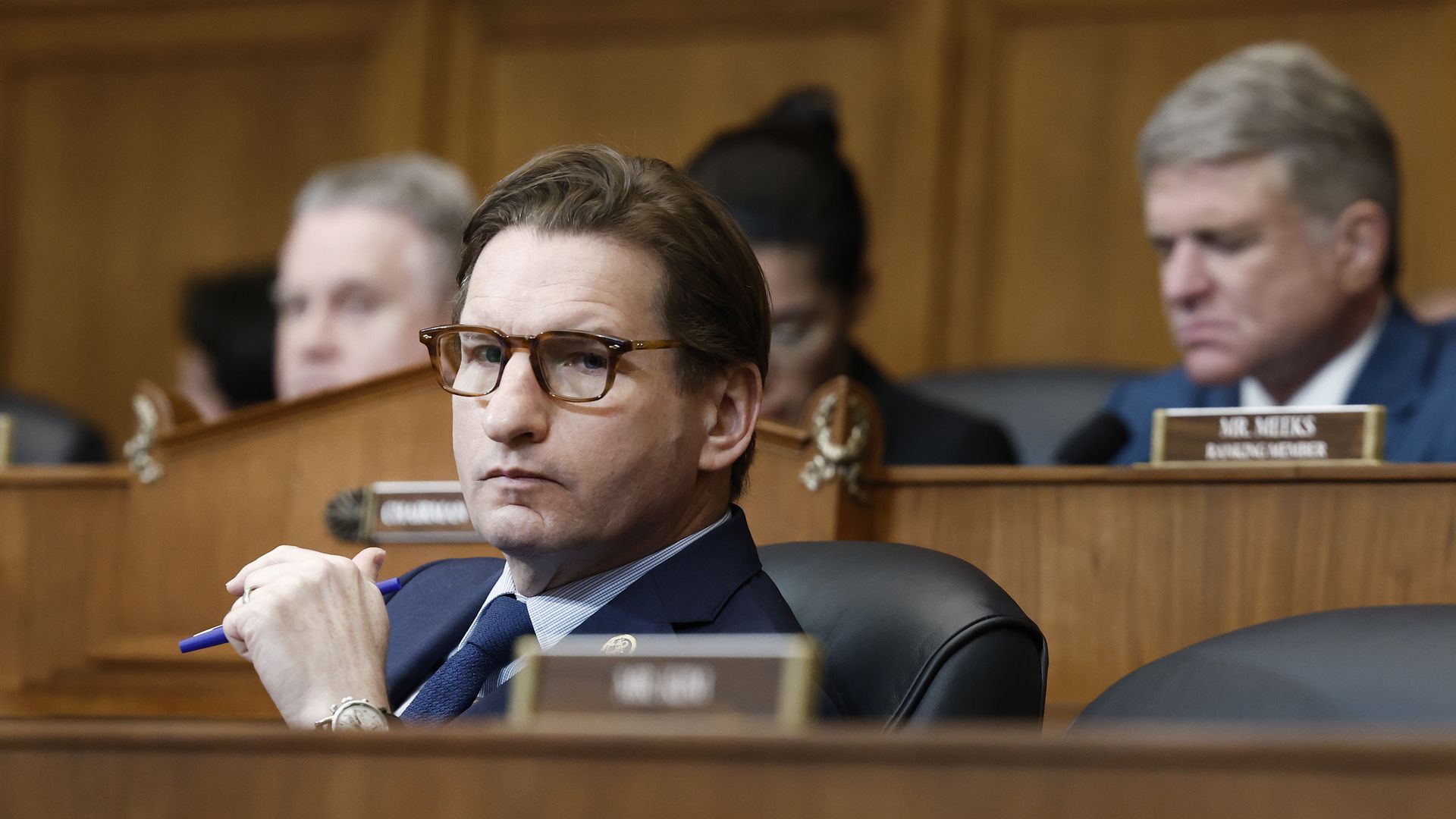 Rep. Dean Phillips, wearing a blue suit and sitting at a committee dais.