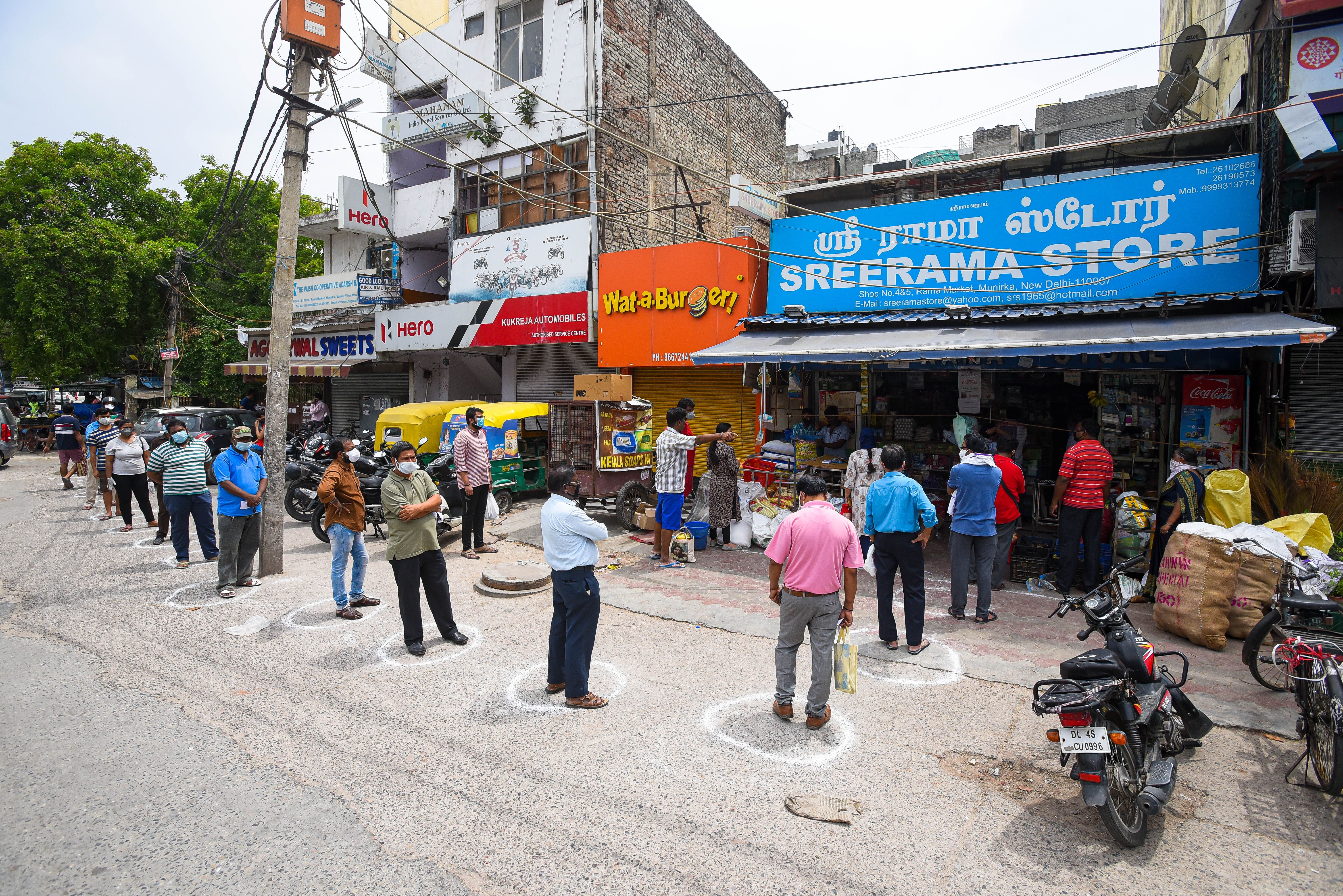 People standing in queue while maintaining distance at a grocery store in Munirka, on May 6, 2020 in New Delhi, India. 
