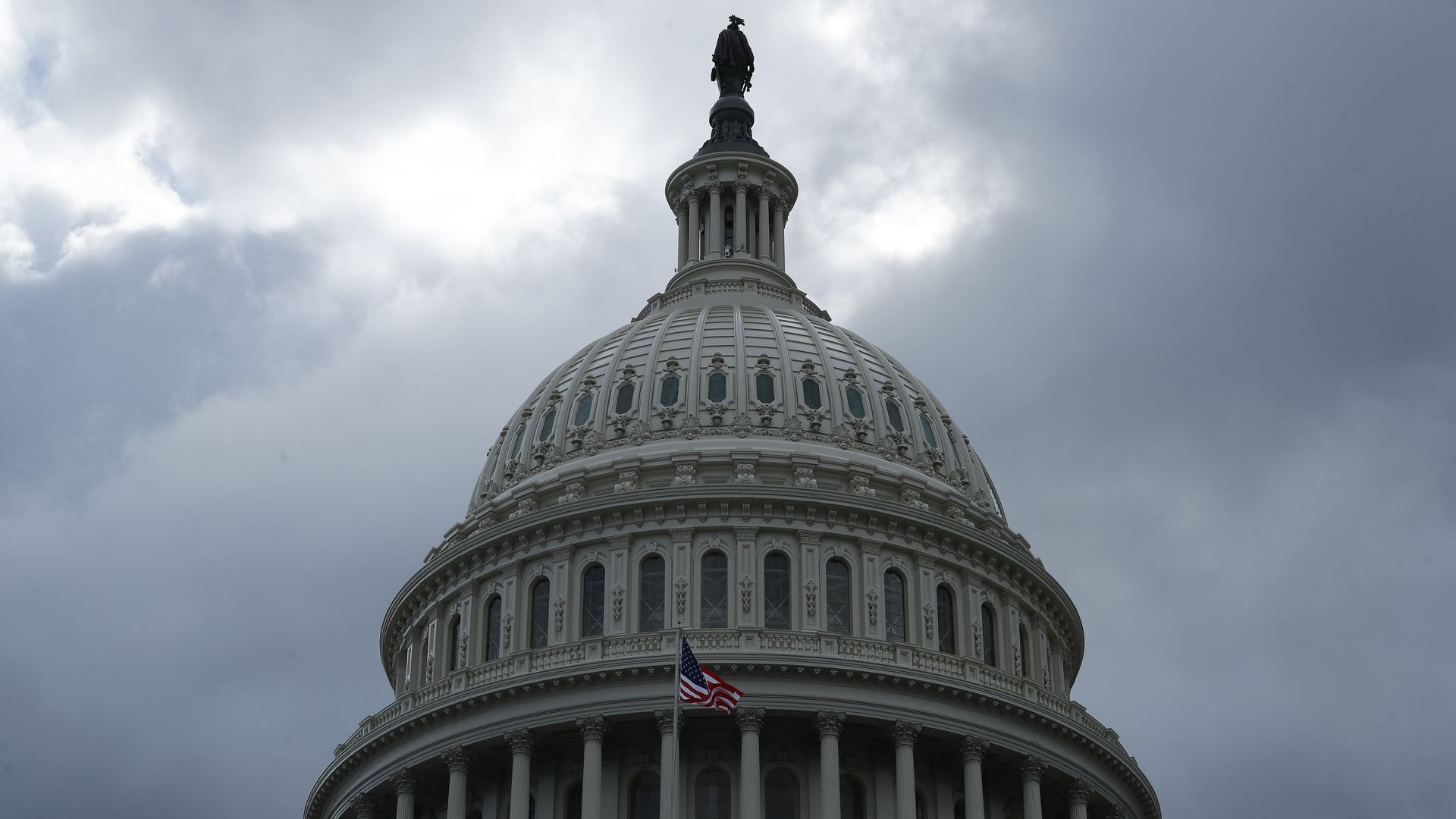 In this image, the dome of the Capitol building is visible against a cloudy sky.