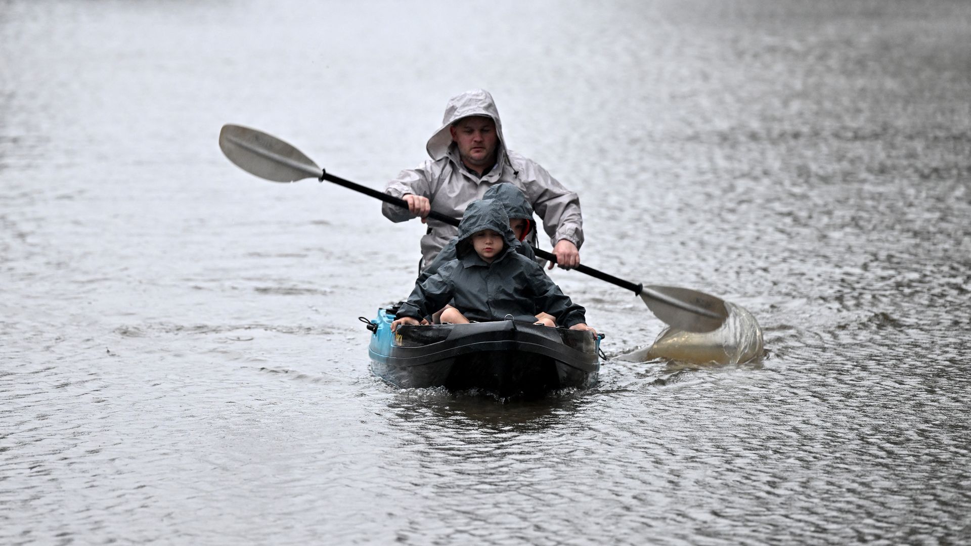 People kayak along a flooded street from the overflowing Hawkesbury river due to torrential rain in the Windsor suburb of Sydney.