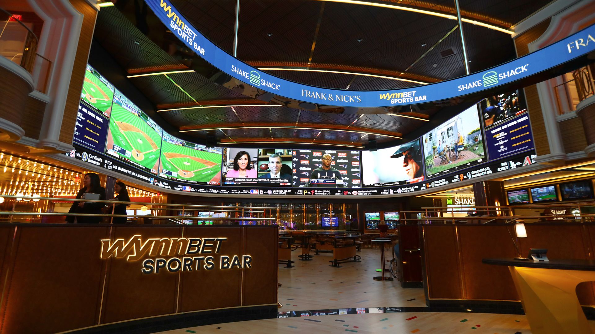 A semi-circle of TV screens shot sports, news segments and more at the WynnBET sports bar inside the Encore Boston Harbor casino.