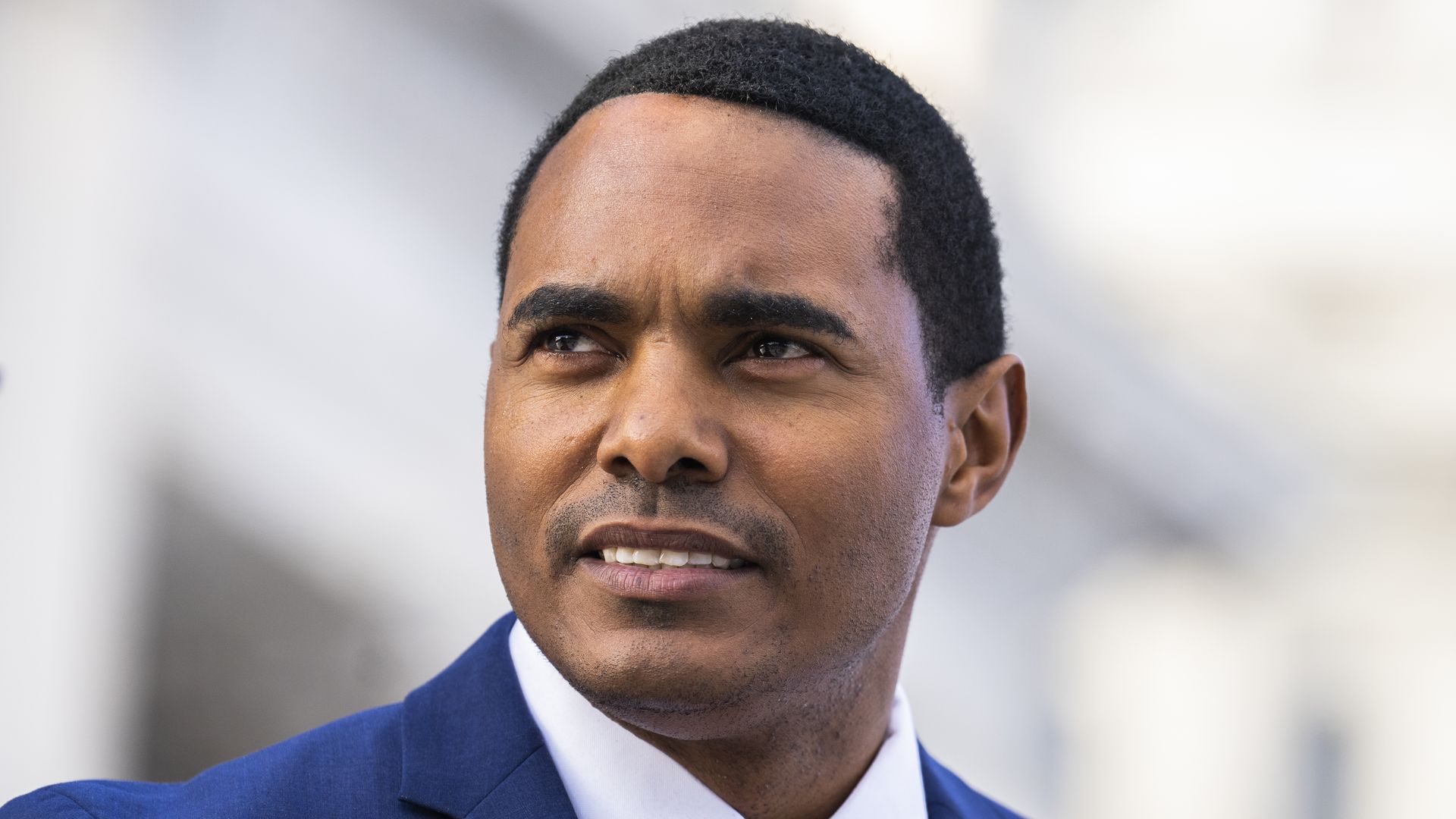 Rep. Ritchie Torres, wearing a blue suit, white shirt and orange tie.