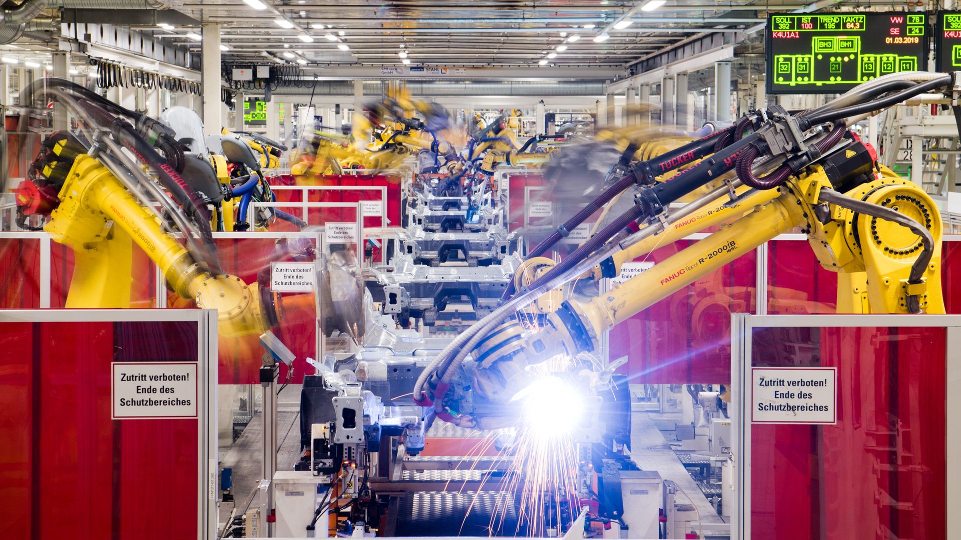 Photo of industrial robots working on cars on an assembly line