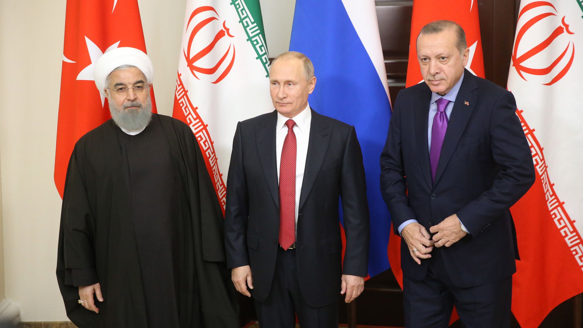Rouhani, Putin, and Erdogan standing in front of national flags