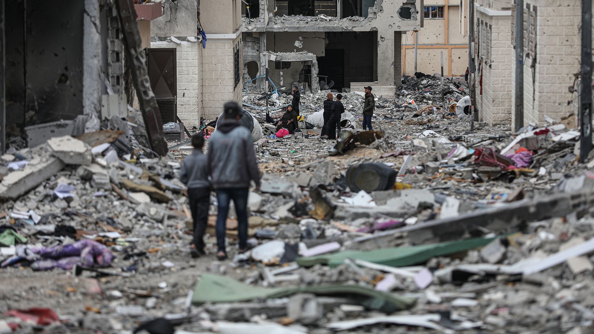 Palestinians walk among the rubble of residential buildings destroyed in Israel's bombardment in southeast Gaza on Nov. 28. Photo: Mustafa Hassona/Anadolu via Getty Images