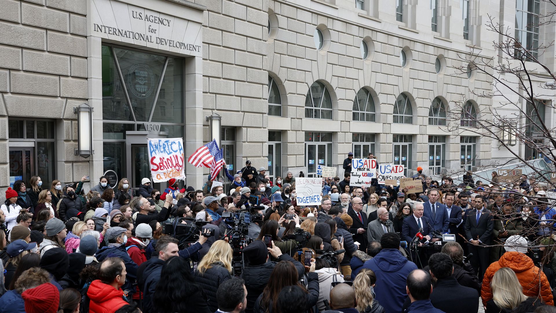 lawmakers and employees and supporters of U.S. Agency for International Development (USAID) speak at a press conference outside of USAID headquarters on February 03, 