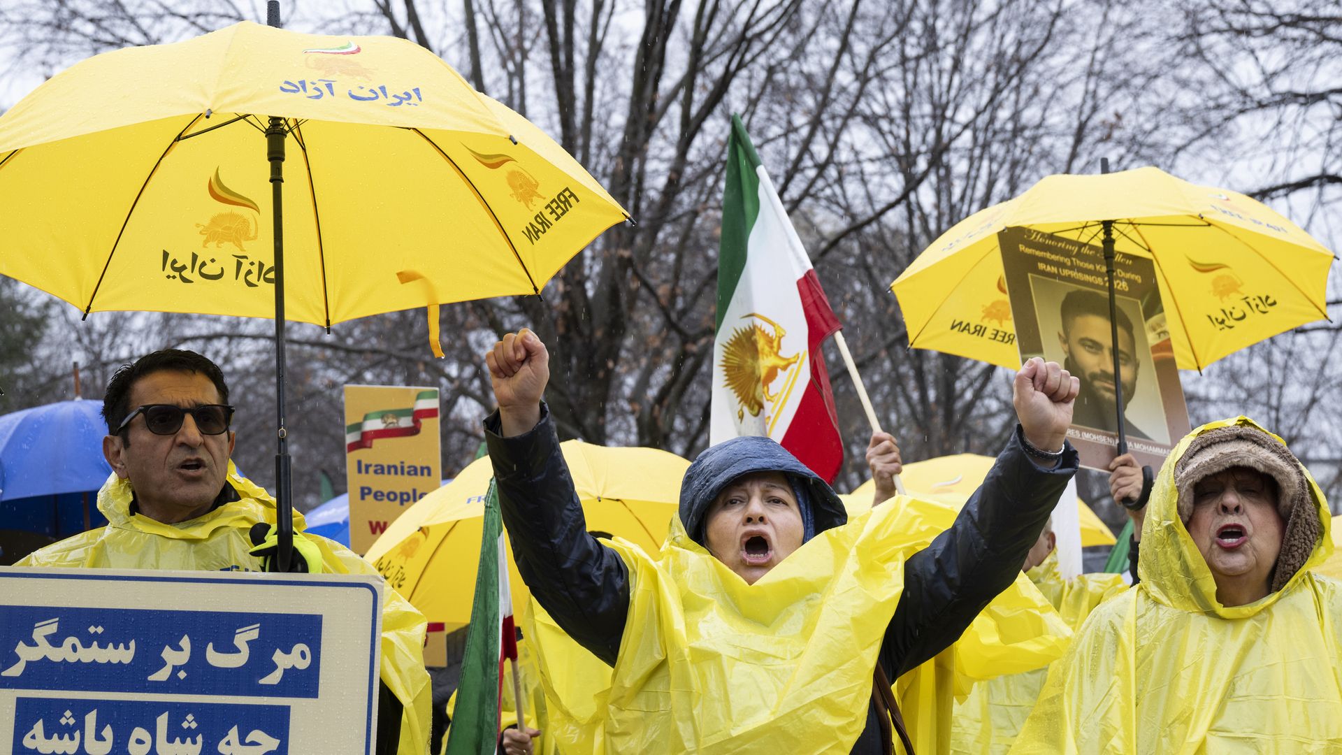 Protesters in yellow ponchos holding yellow umbrellas and signs