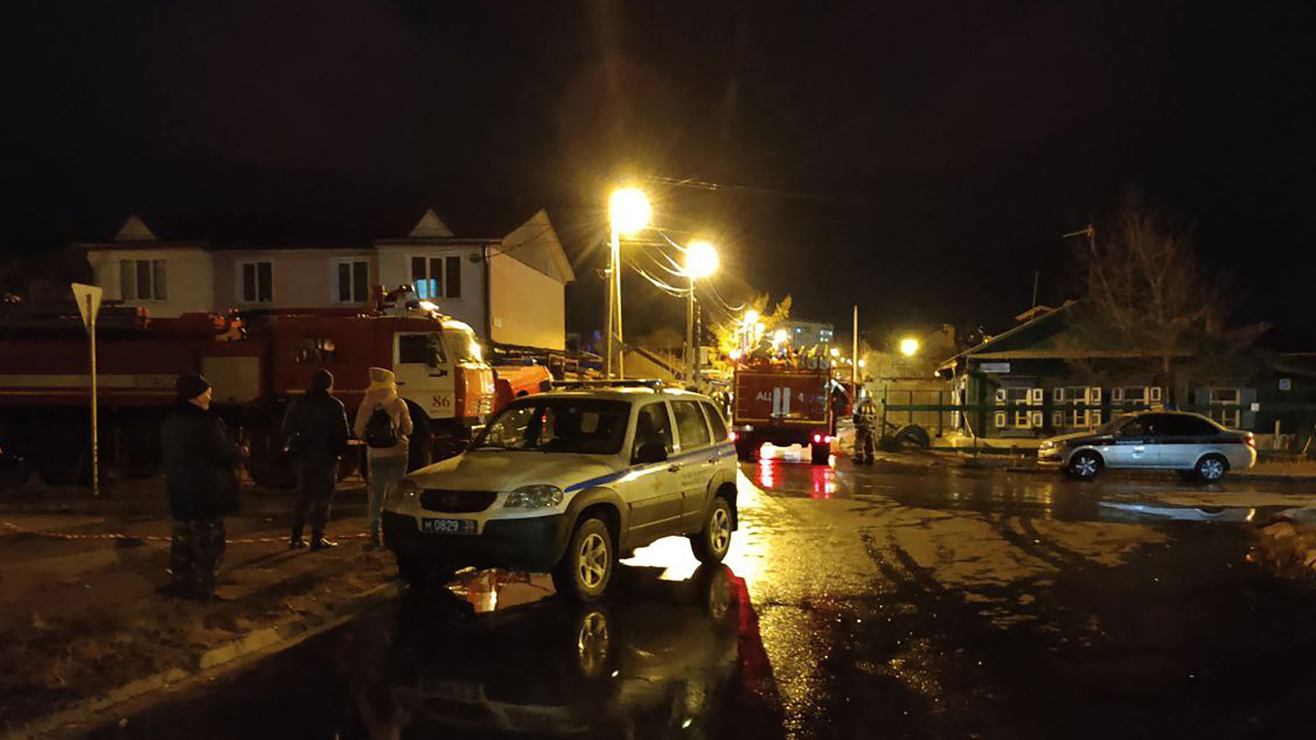 A picture taken late on October 23, 2022, shows emergency personnel working at the crash site of a military jet in a residential area in Irkutsk, Siberia, southeastern Russia. 
