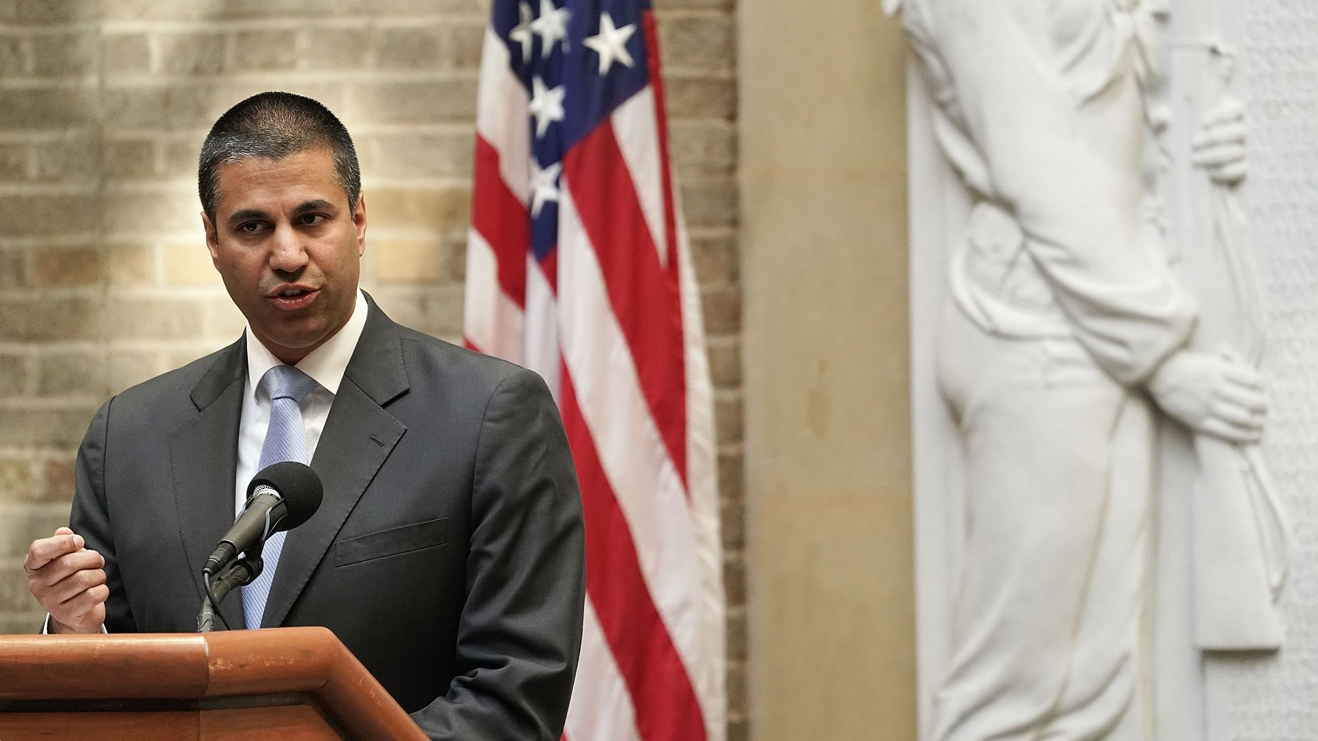 FCC Chairman Ajit Pai speaks in front of an American flag