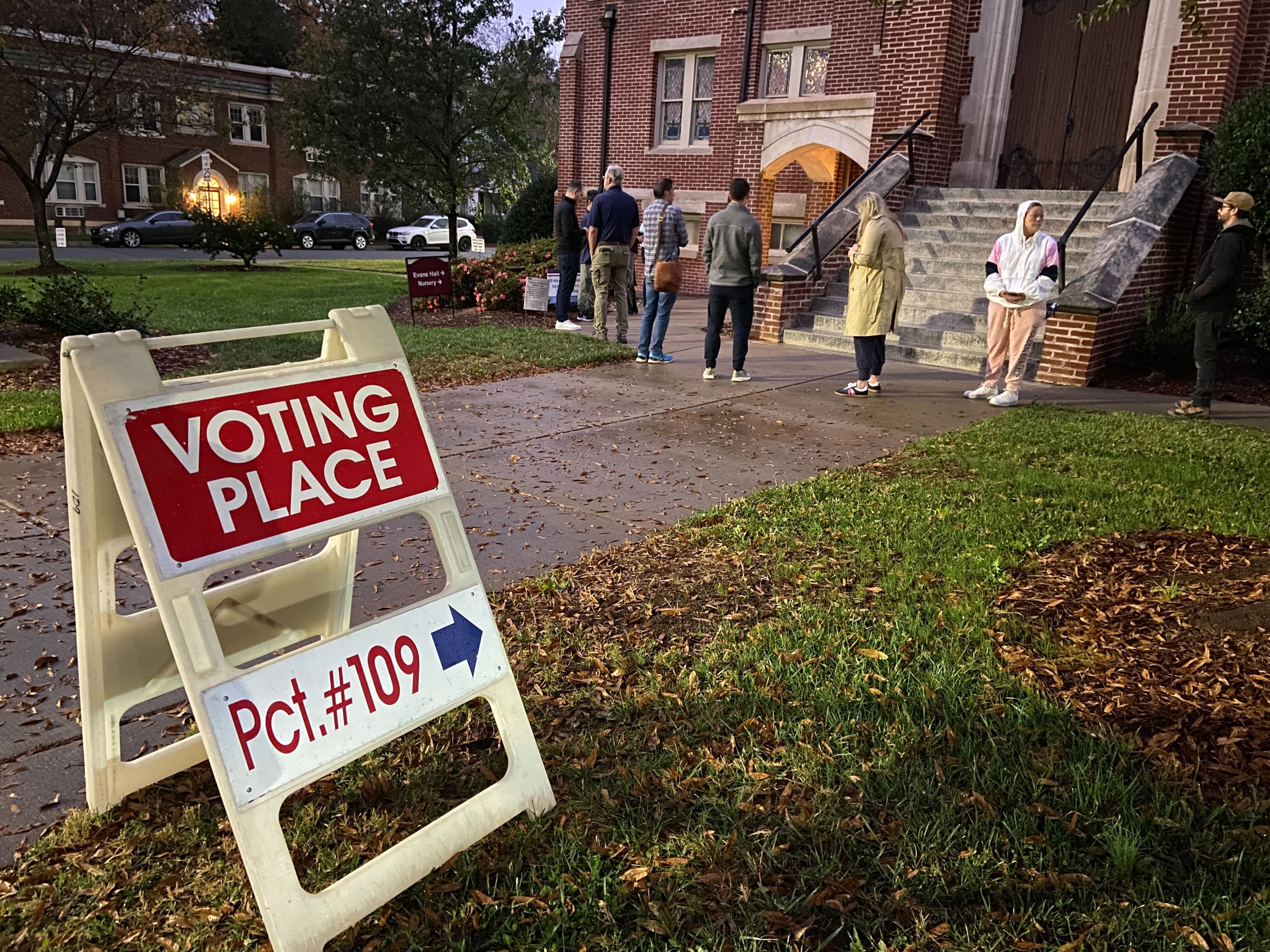 voting place sign points to line outside church