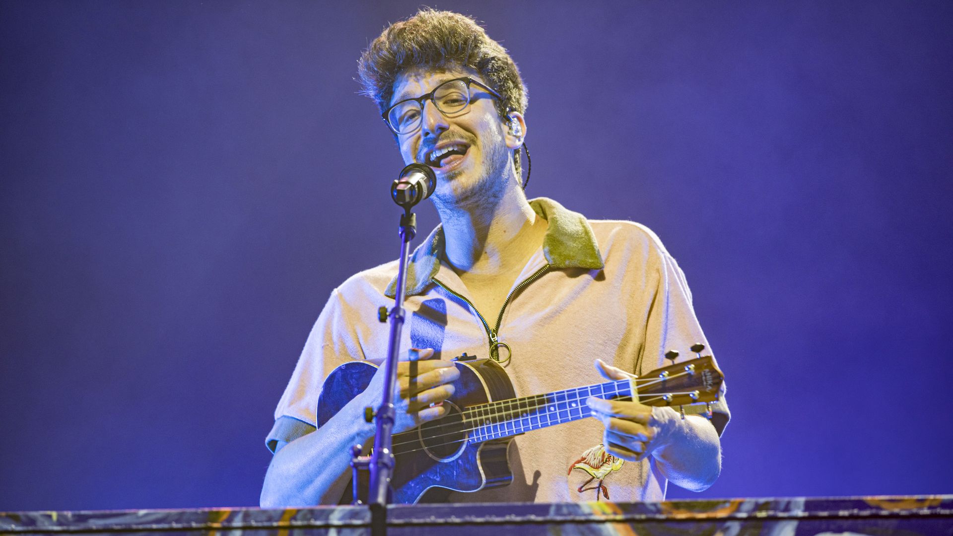 A man singing with a small guitar.