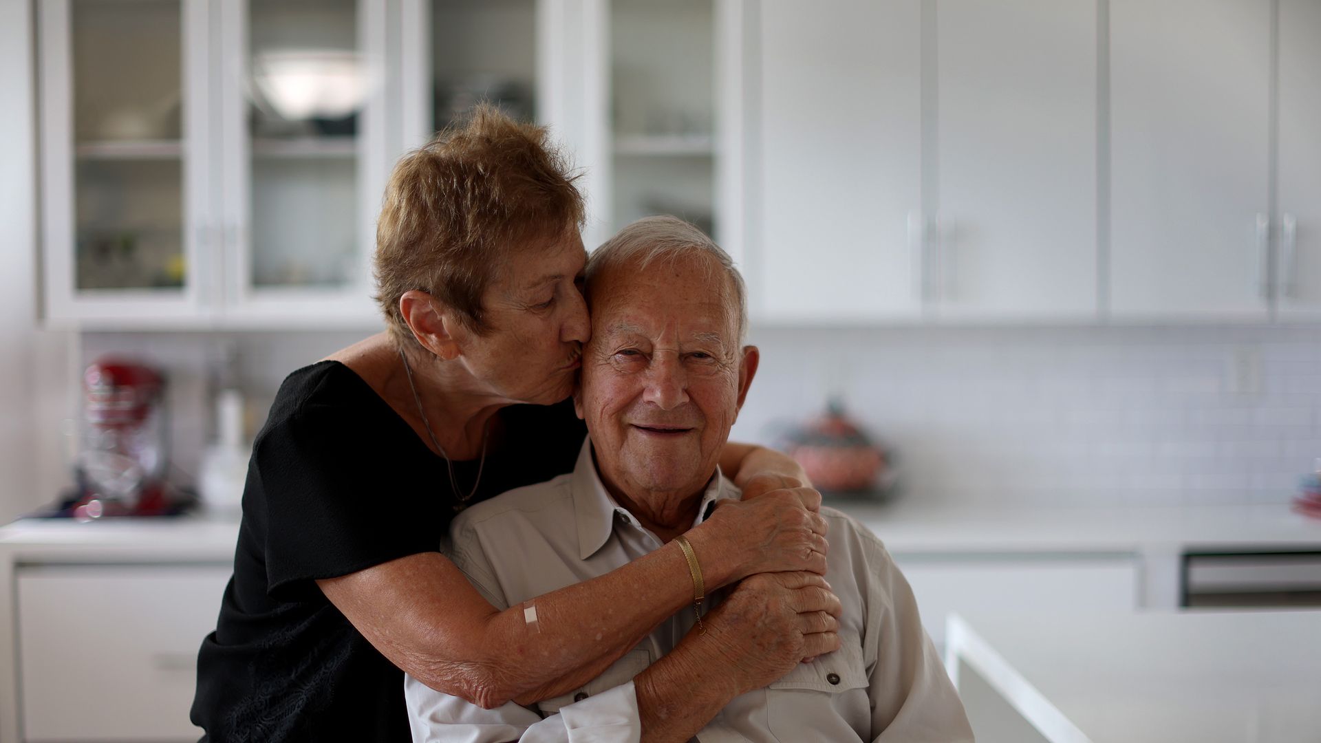 Sandy Gurowski hugs her husband Manny Gurowski, 91, a child survivor of the Holocaust, as they pose in their home on Jan. 26, 2023 in Delray Beach, Florida. 