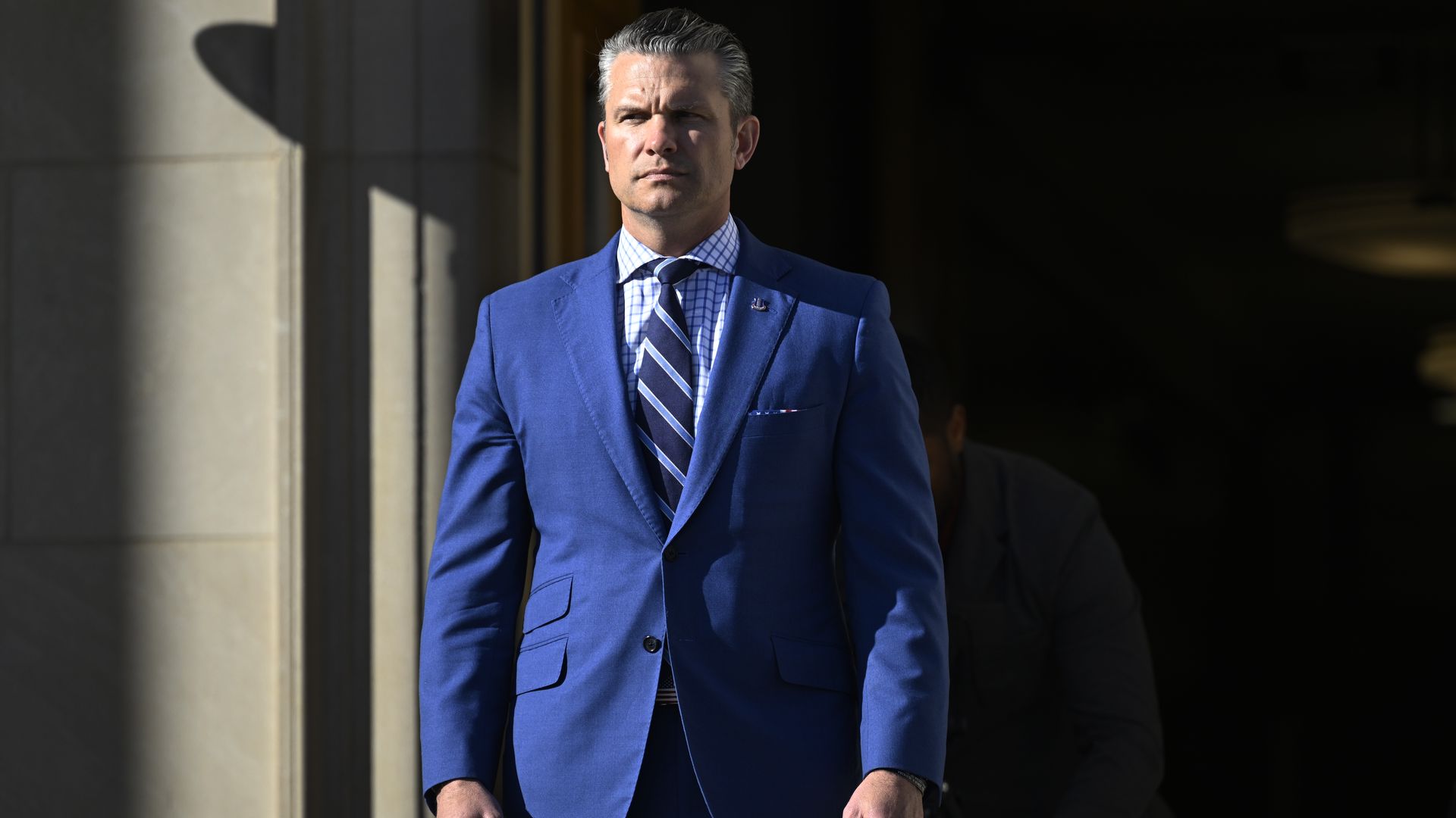 Hegseth suited and standing