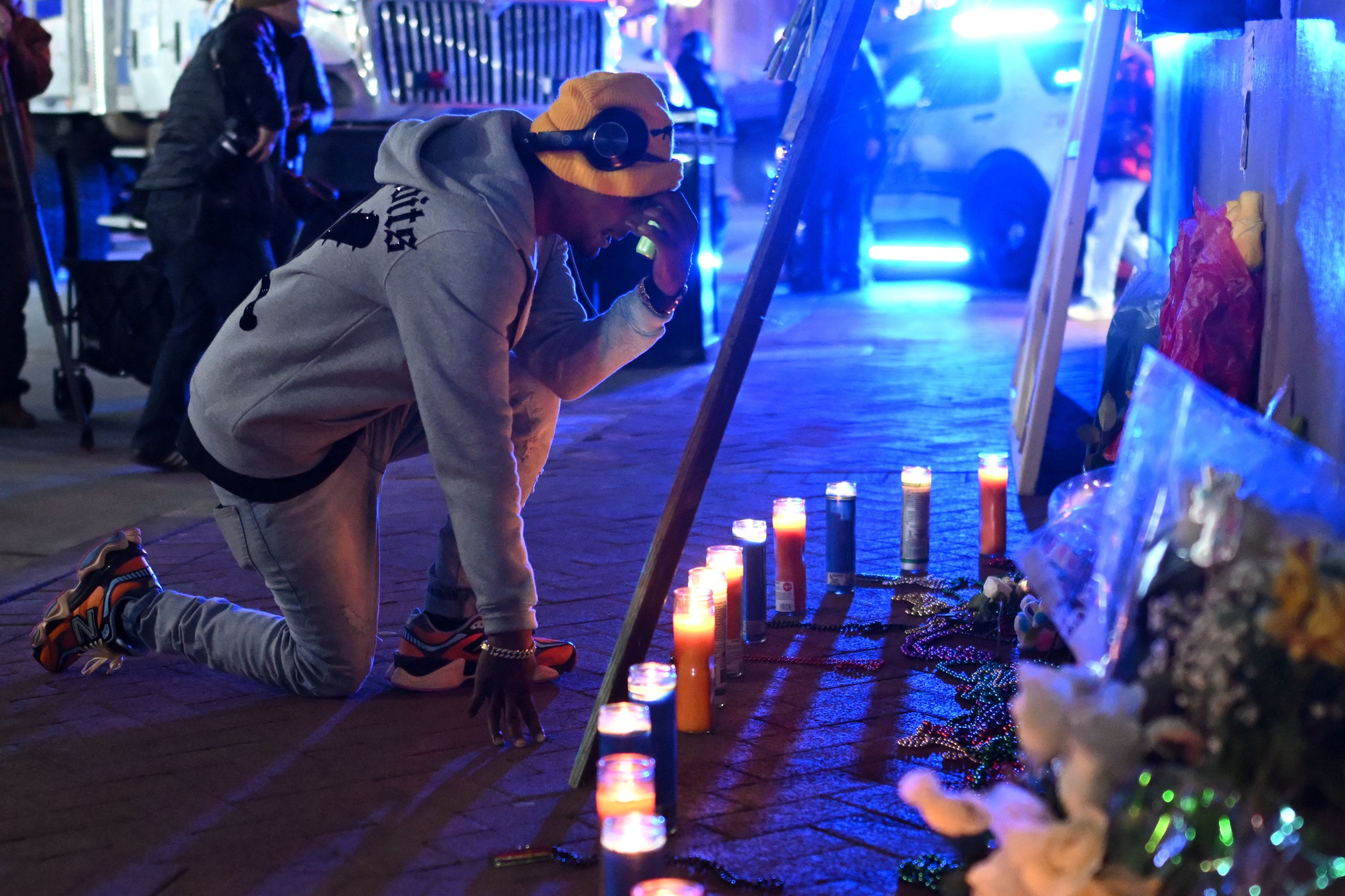 photo shows a man kneeling in front of a memorial