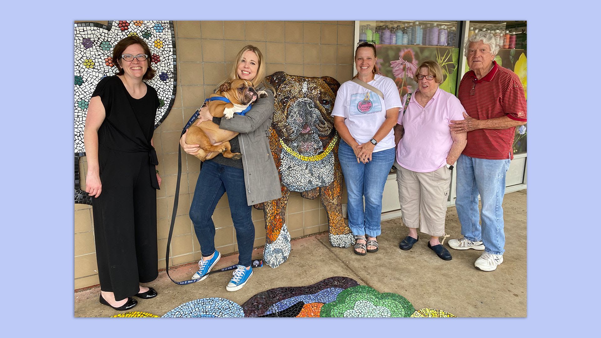 Three women (Artist Nicole James, Maggie Moller and Leslie Hunter) stand in front of James' mural of Moller's dog Frida.