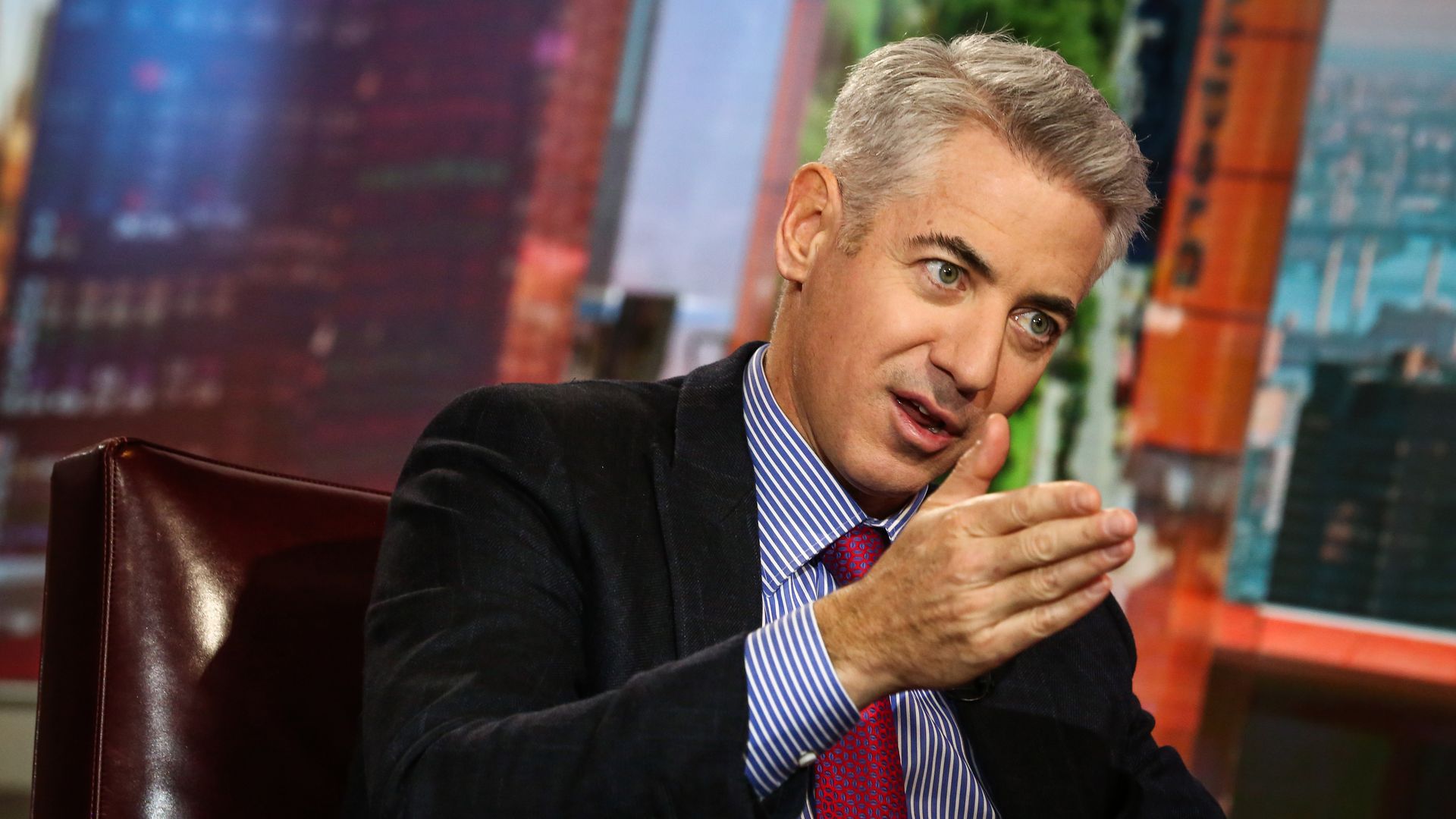 Bill Ackman, seated, speaking while gesturing with his right hand.