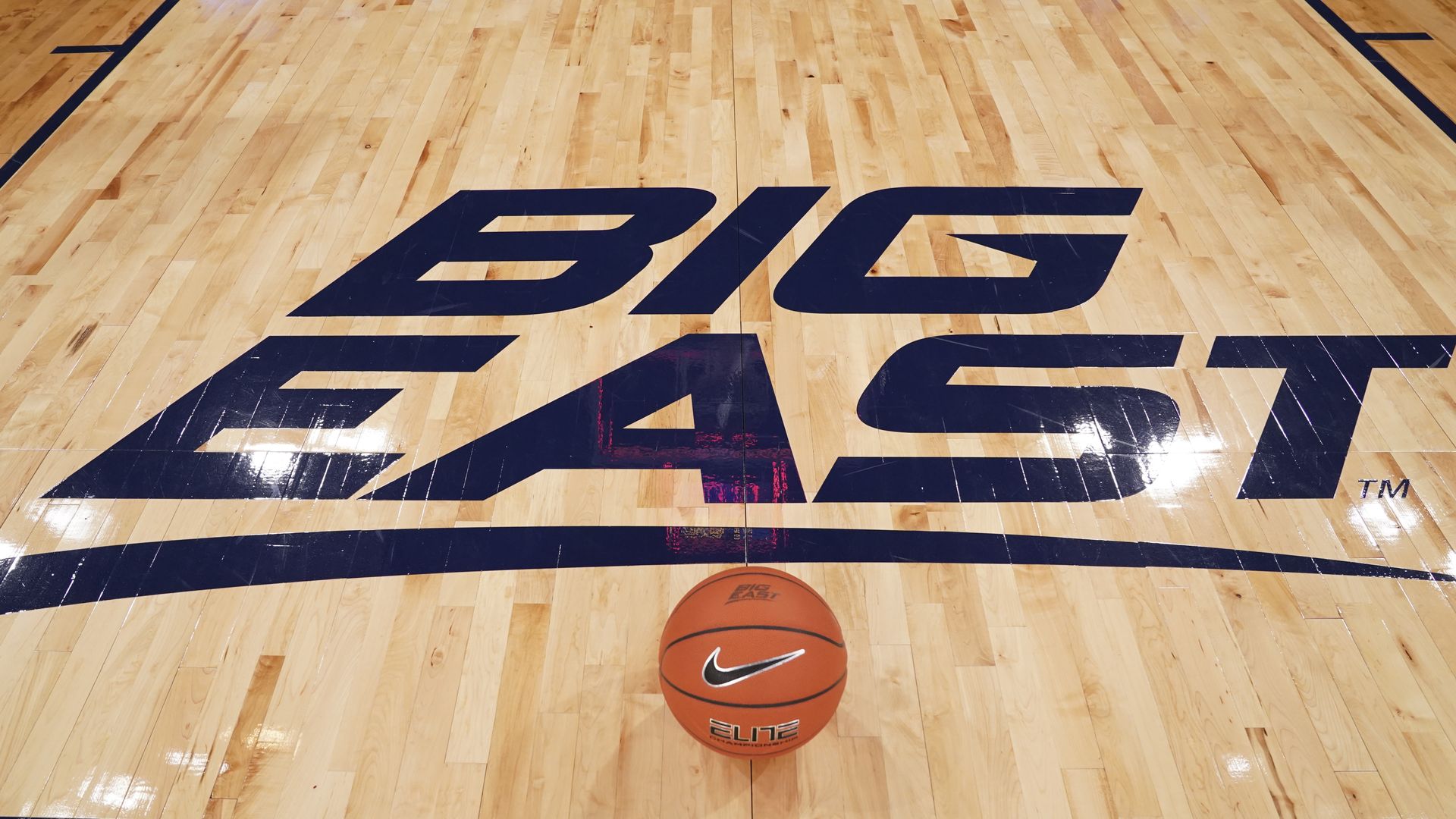 Photo of a ball that is on a court that says "Big East" 