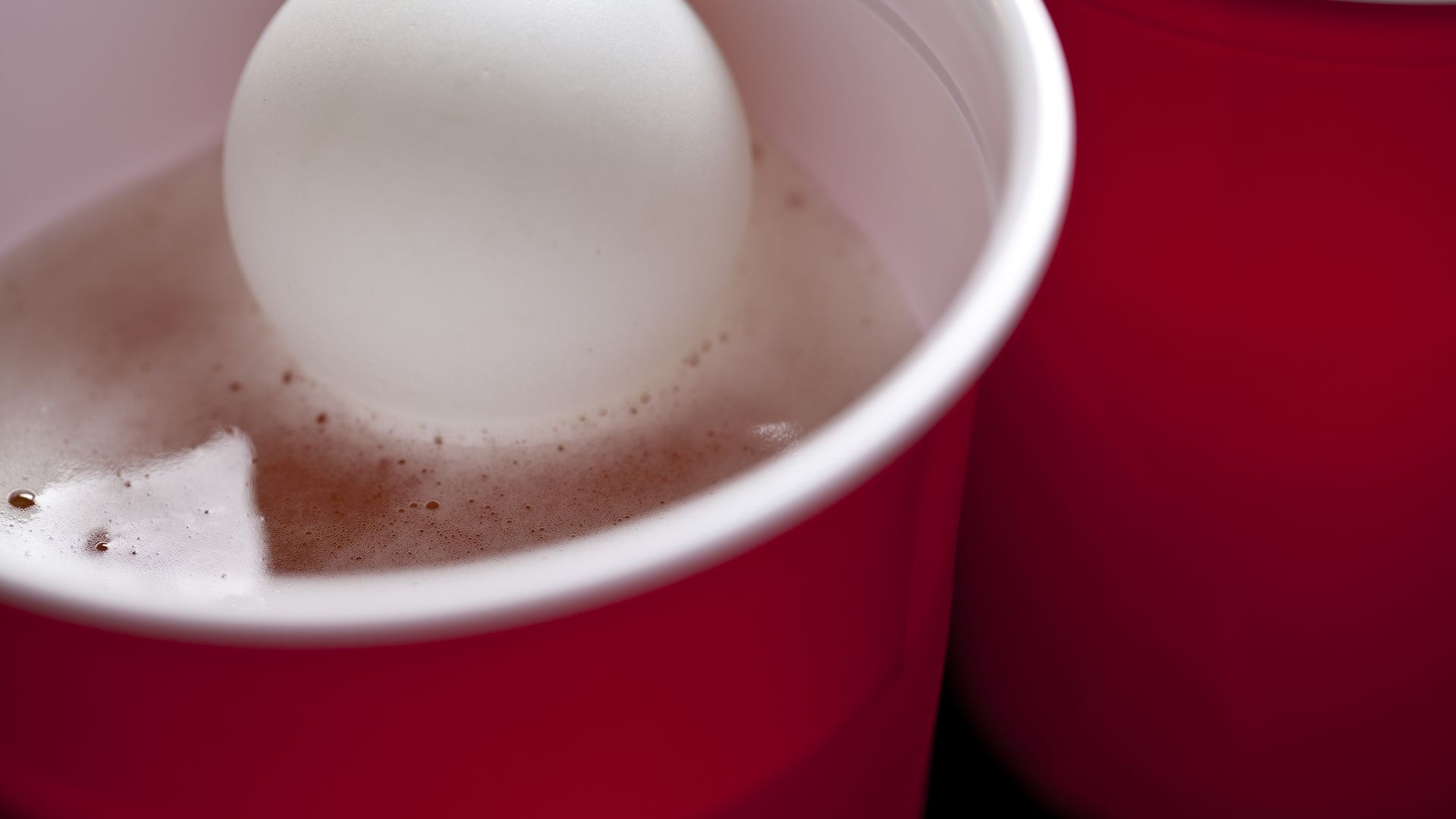 Cup and ball used in beer pong.