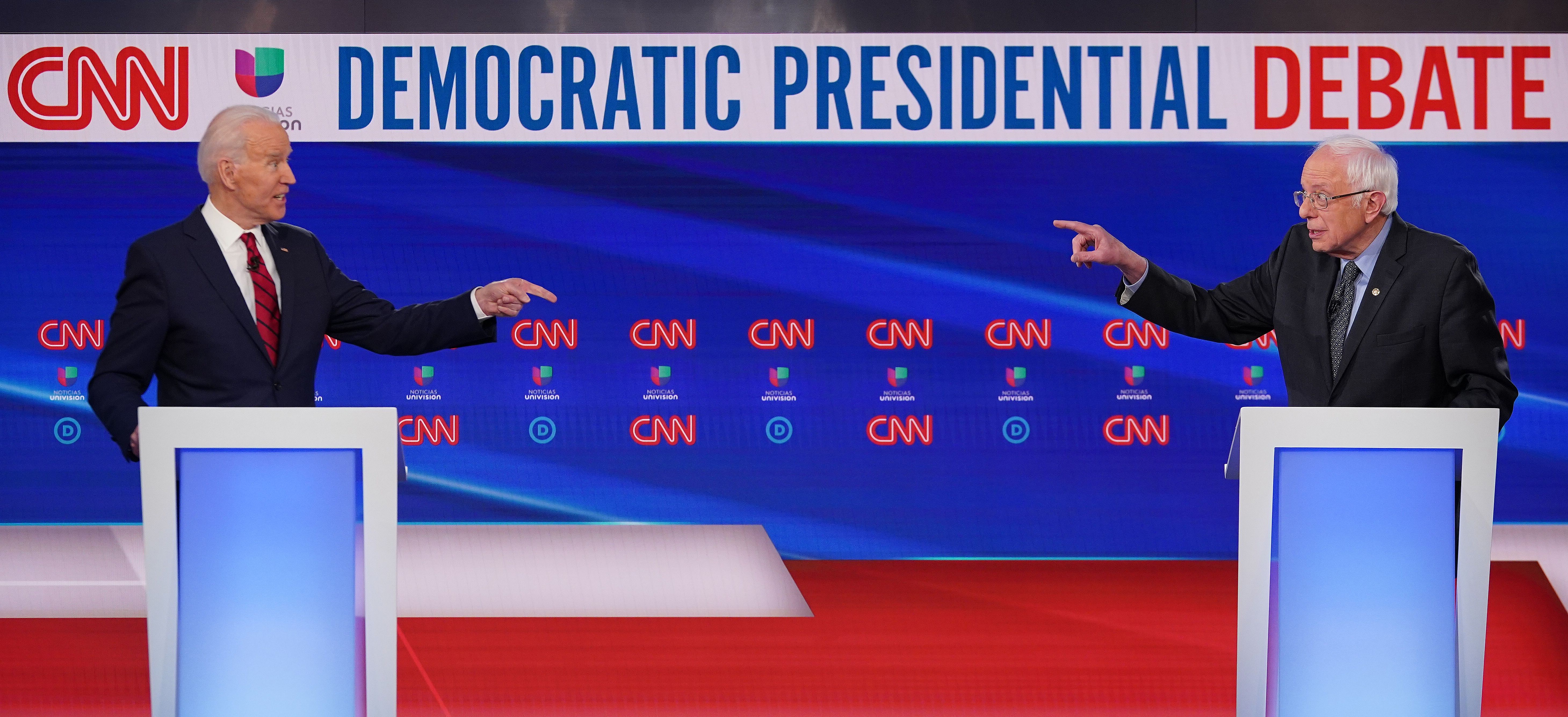Joe Biden and Bernie Sanders pointing at each other 
