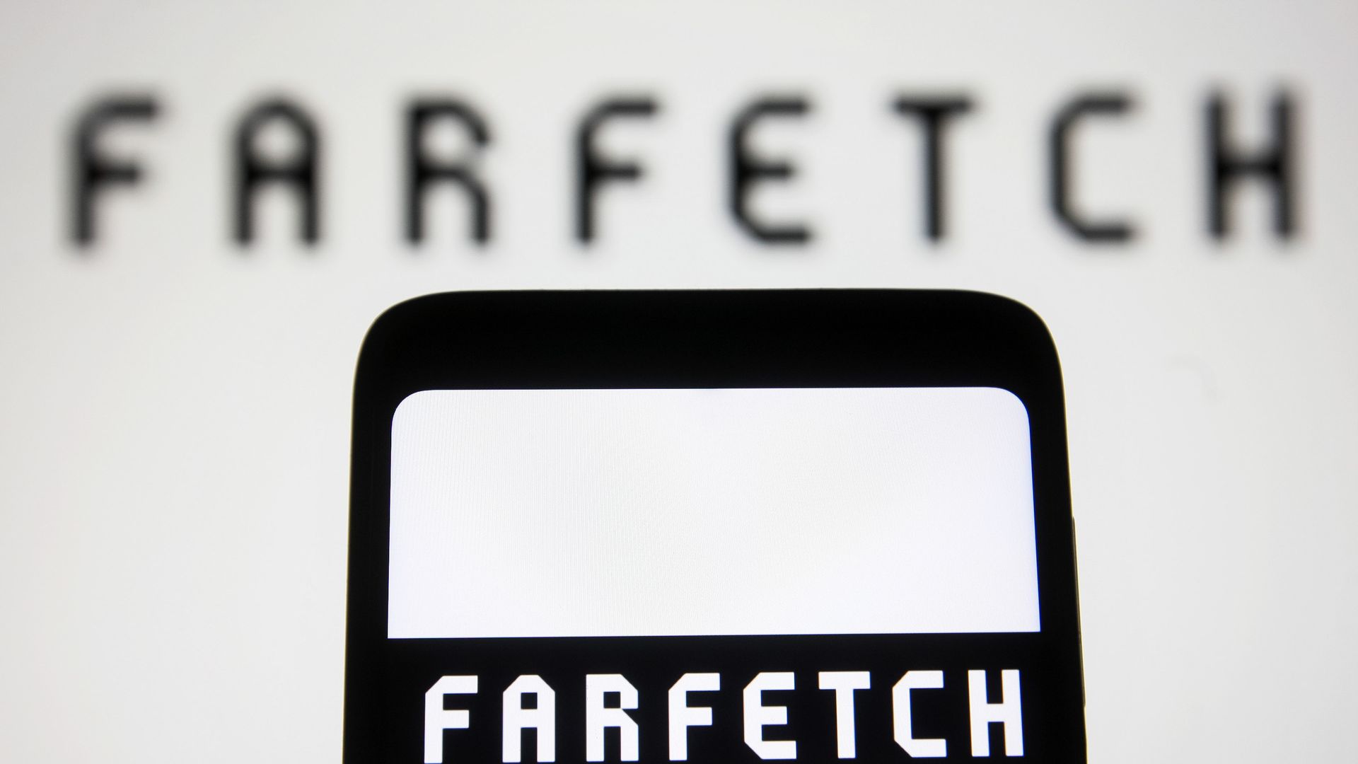 the Farfetch logo is displayed on a smartphone screen and in the background. (Photo Illustration by Pavlo Gonchar/SOPA Images/LightRocket via Getty Images)