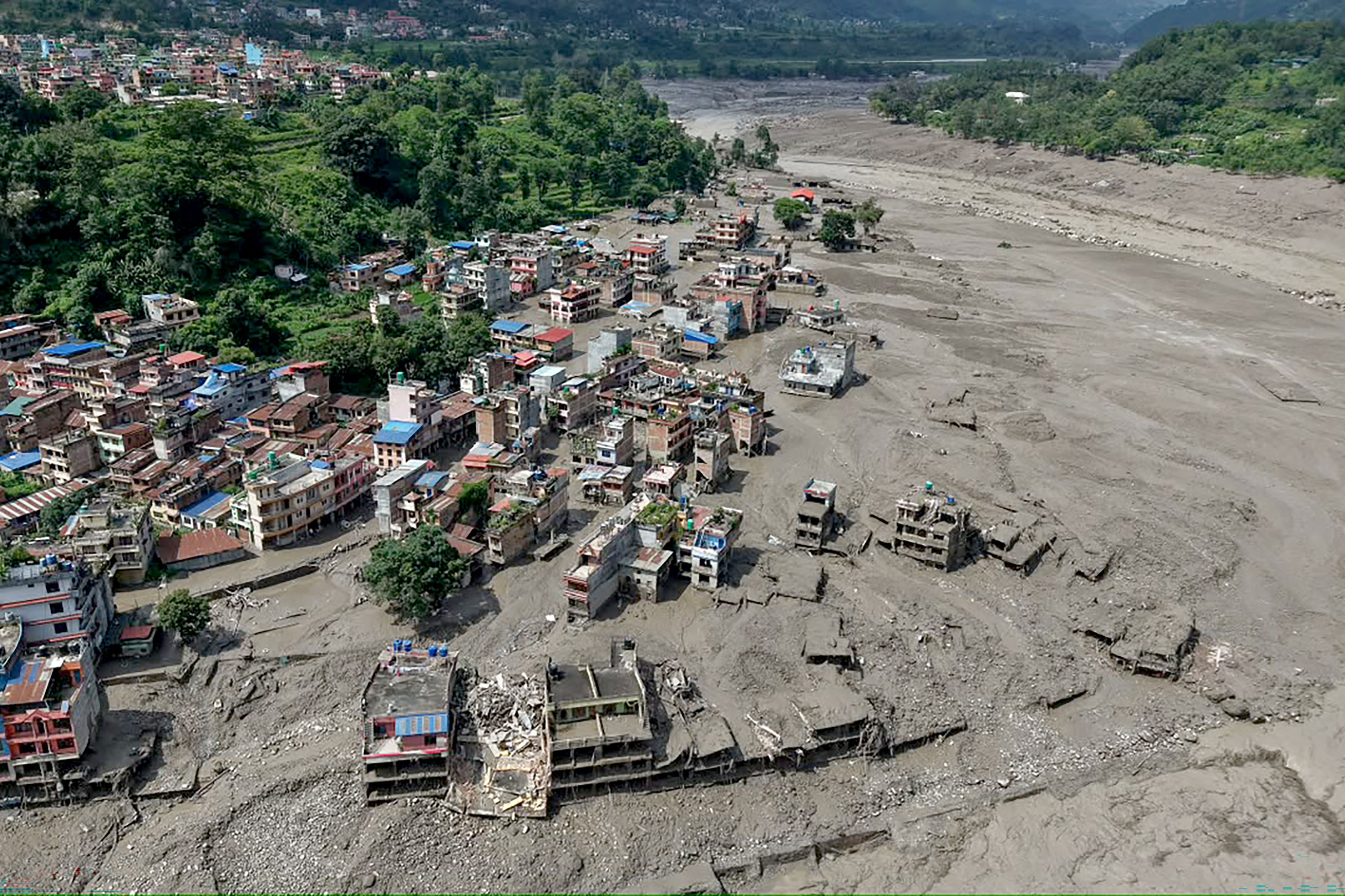 Houses partially submerged in muddy water in aerial shot
